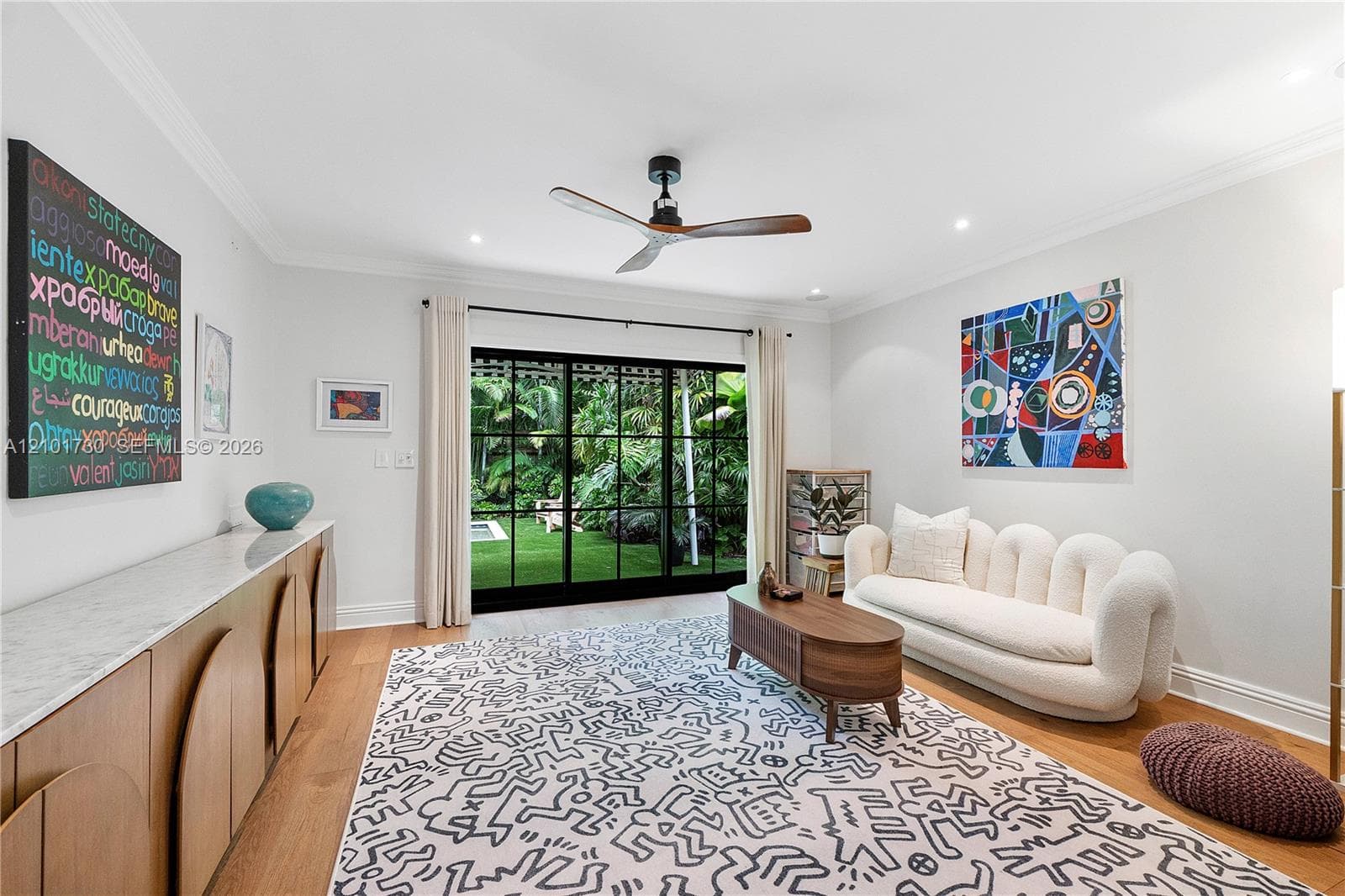 Living area featuring wood-finish flooring, recessed lighting, crown molding, a ceiling fan, and black-framed sliding glass doors