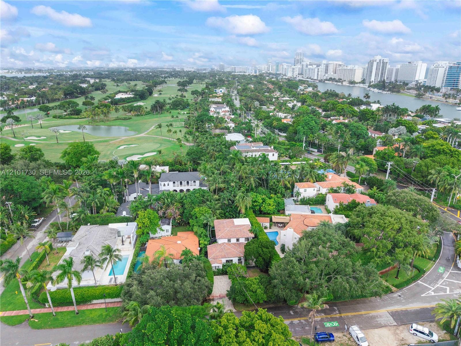 Aerial perspective featuring lush tropical landscaping, proximity to the waterfront, and expansive golf course grounds