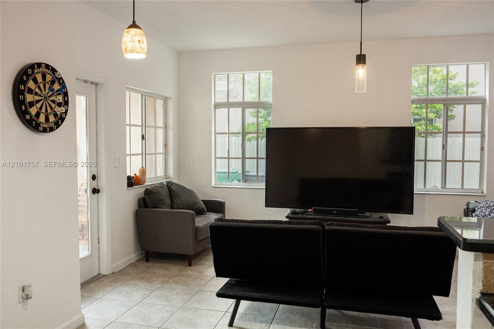 Tiled flooring throughout, multiple windows with grid patterns, and two distinct pendant light fixtures