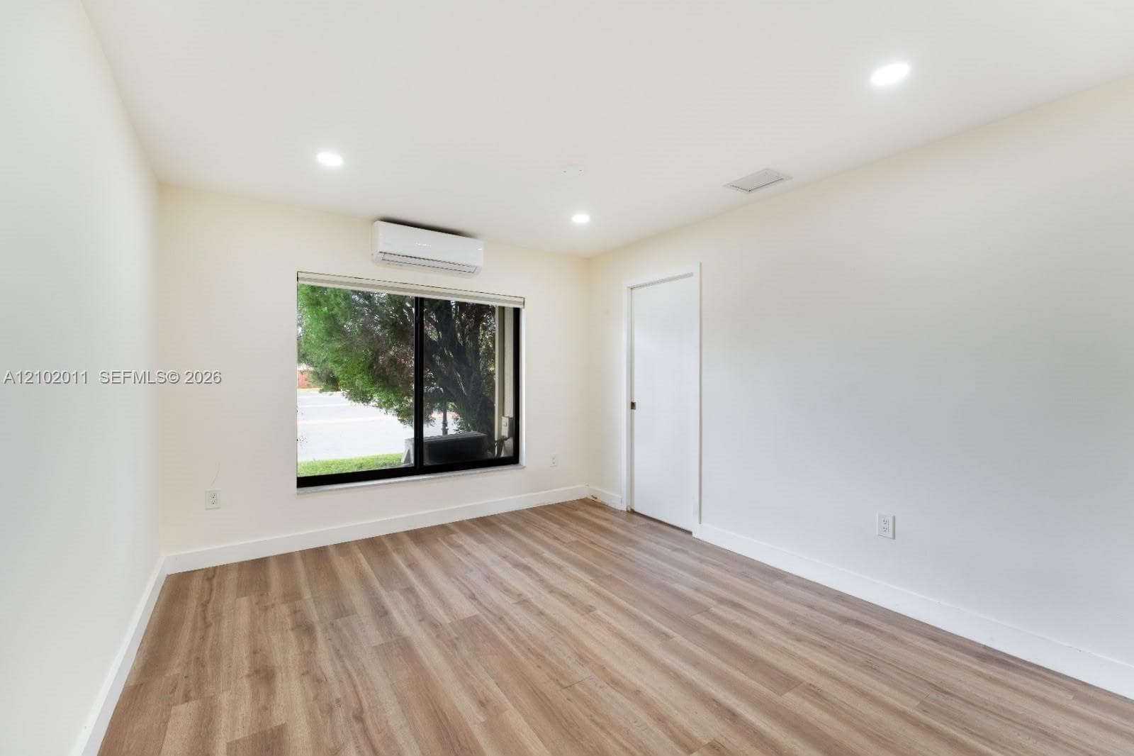 Recessed ceiling lighting, wood-finish flooring, and a mini-split air conditioning unit