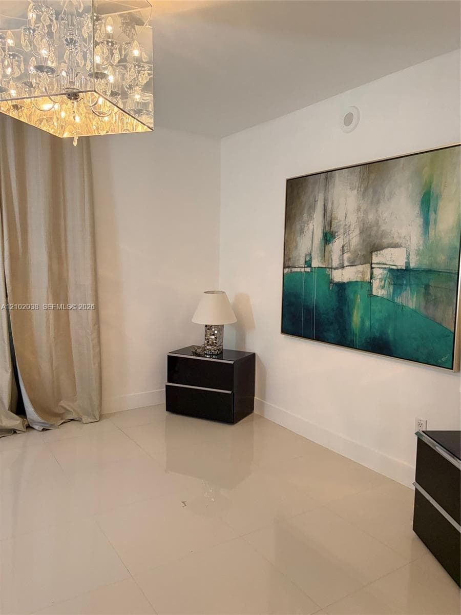 Polished tile flooring and a square flush-mount crystal chandelier