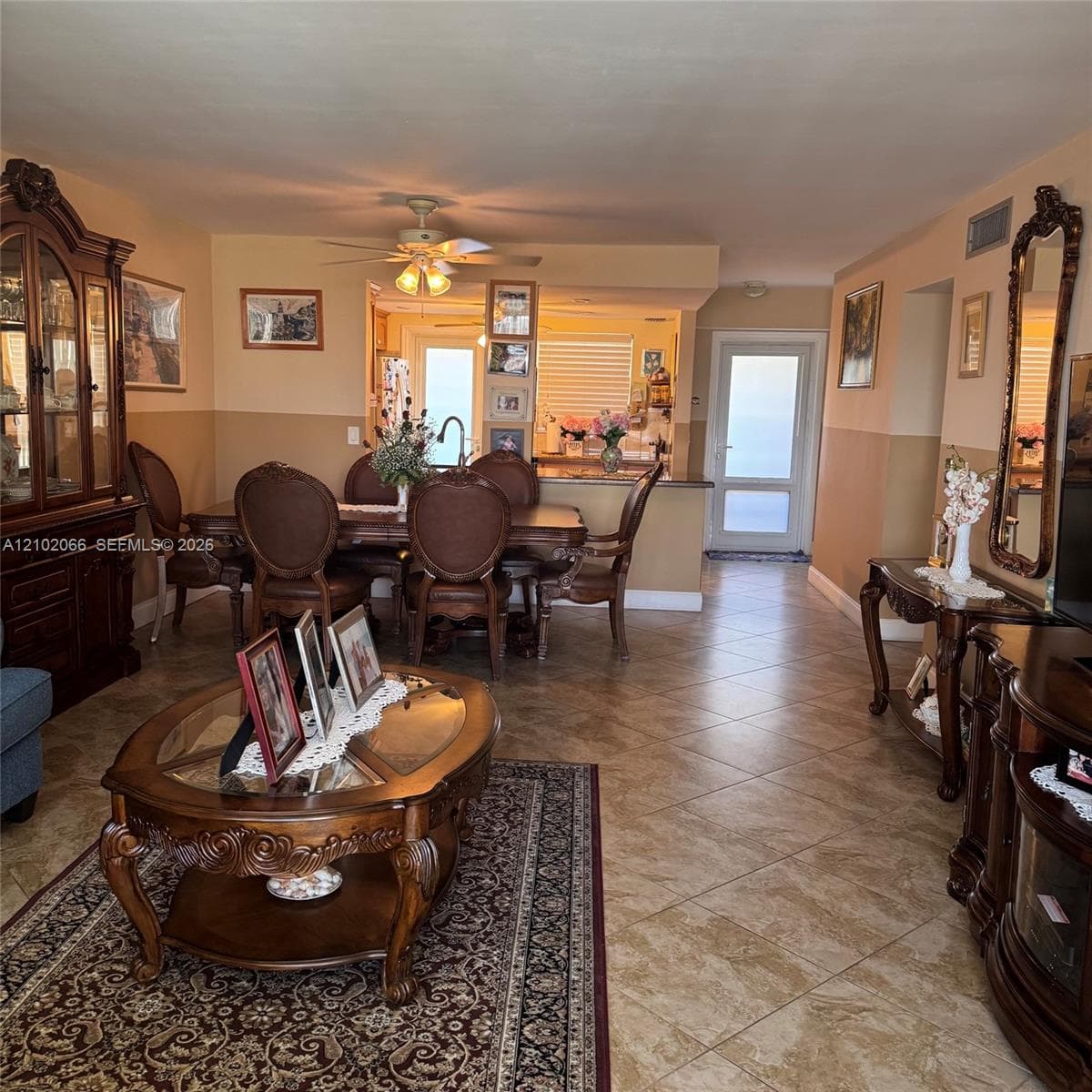 Open-concept floor plan featuring diagonal ceramic tile flooring, a peninsula counter with breakfast bar seating, and a multi-lite exterior door