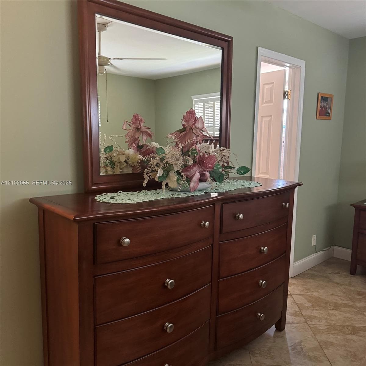Ceramic tile flooring, six-panel interior door, and ceiling fan fixture