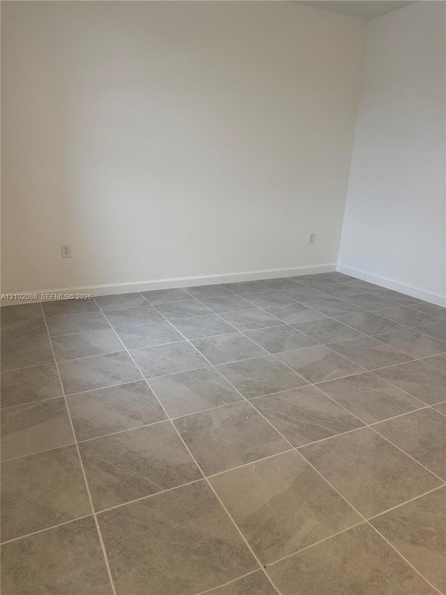 Neutral interior room featuring large-format grey tile flooring and light-toned wall finishes