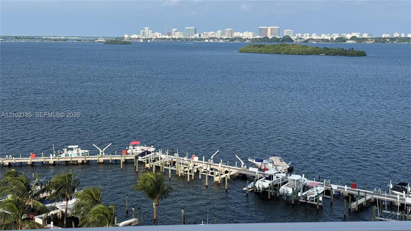 Direct water frontage featuring a private multi-slip dock and an expansive bay expanse with distant city skyline