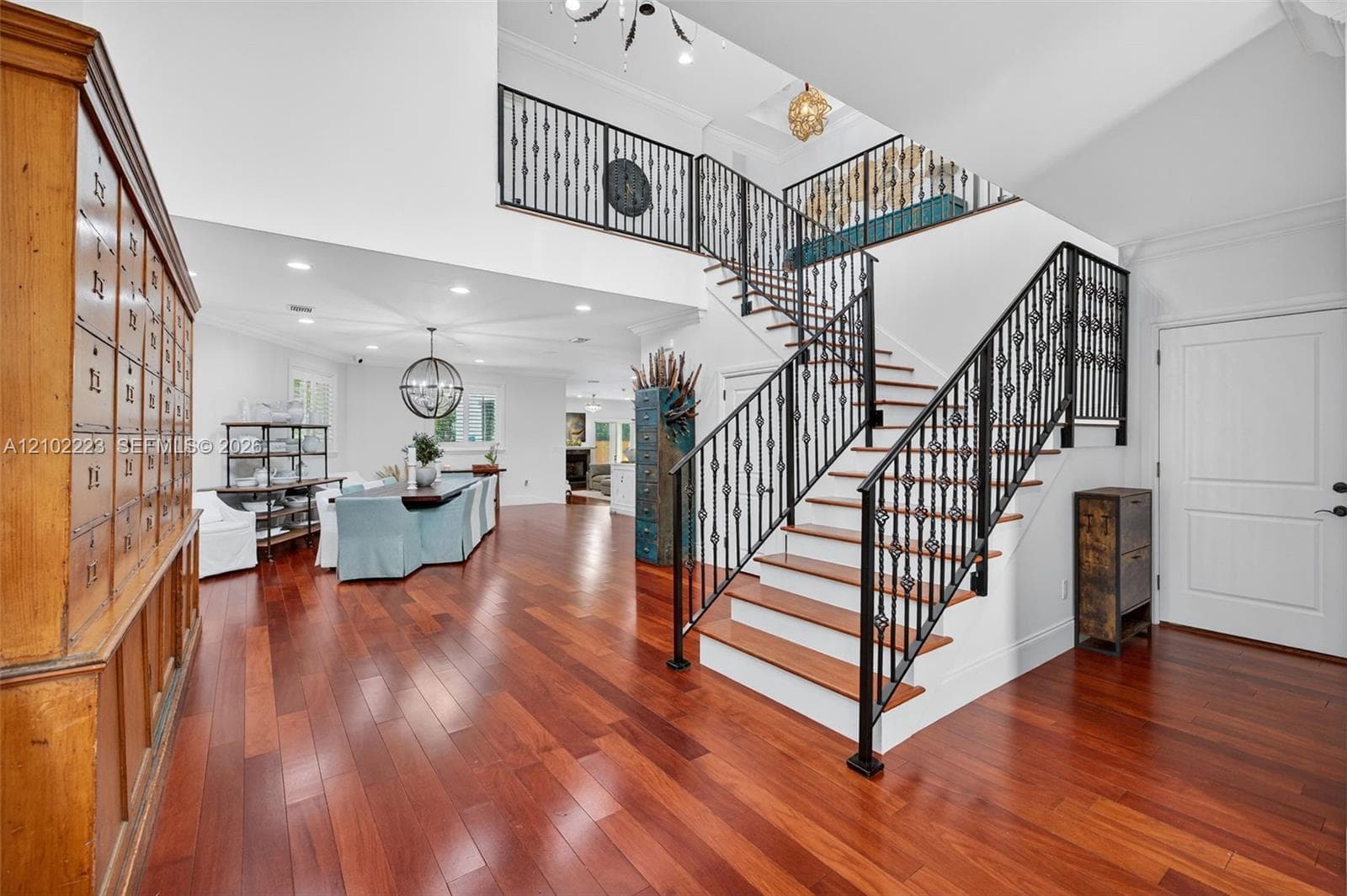 A striking architectural staircase with decorative rod, iron railings and warm wood, treads adds character and sophistication to the grand entry. Rich hardwood floors, soaring ceilings and an open view of the upper level. Create a wonderful sense of space while connecting the homes, beautiful designed living areas.