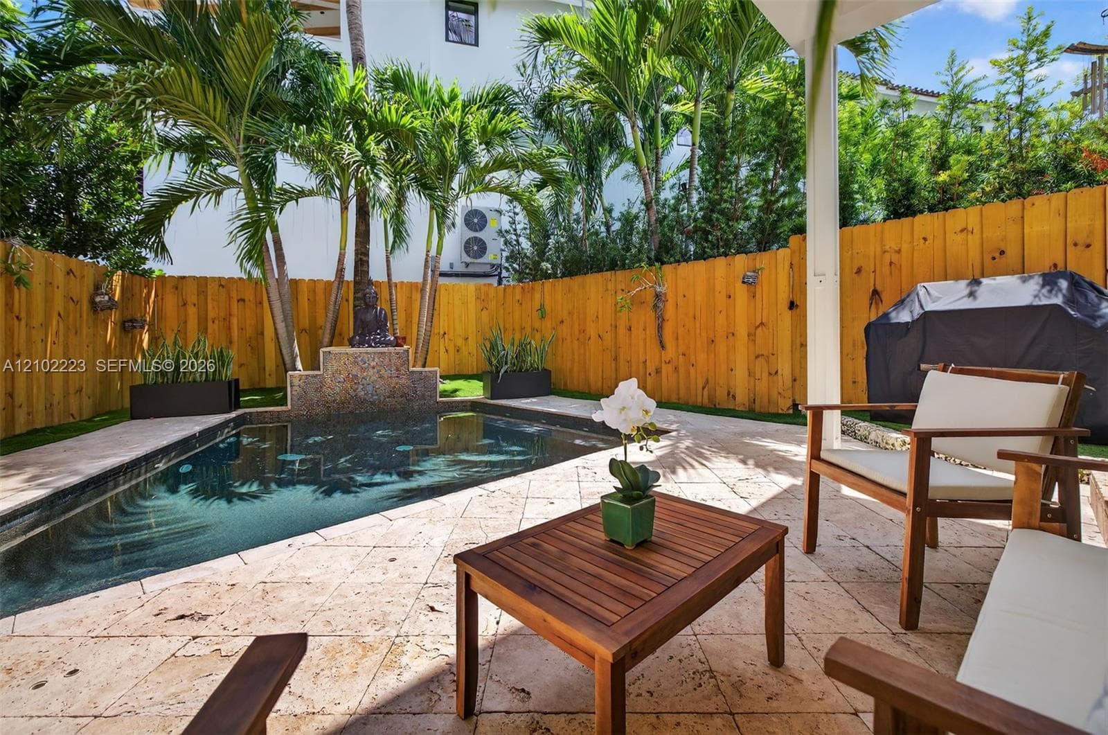 A charming boutique style tropical oasis, where swaying palms cascading waterfall in a sparkling saltwater pool create an inviting setting for relaxation. The covered lounge area offers a lovely spot to unwind while the thoughtfully designed low maintenance surroundings make enjoying the South Florida lifestyle effortless.