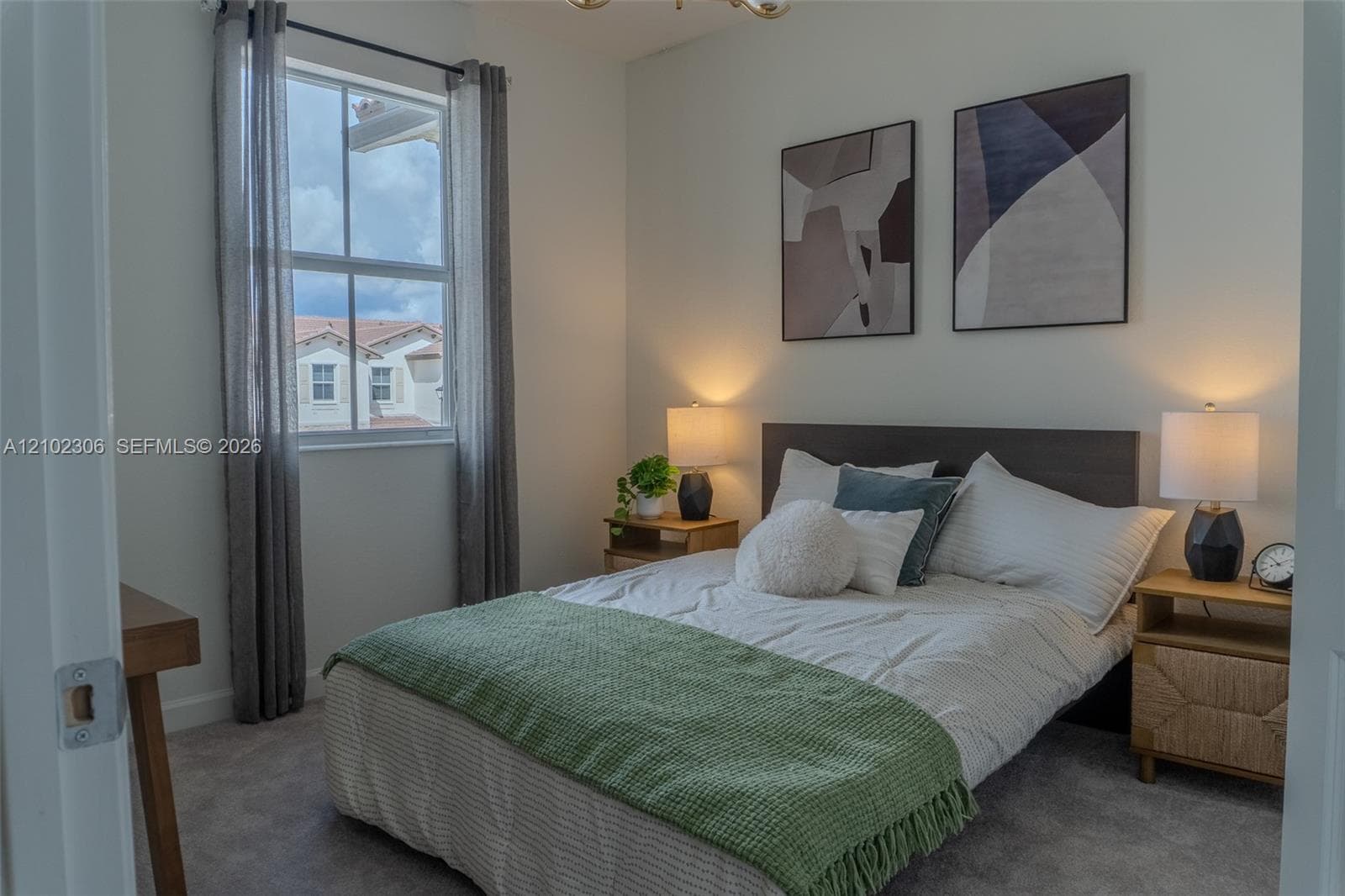 Neutral wall tones, carpeted flooring, and a single-hung window with natural light