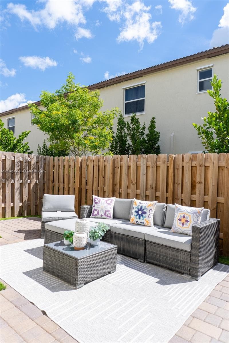 Private patio featuring concrete paver flooring and a natural wood privacy fence