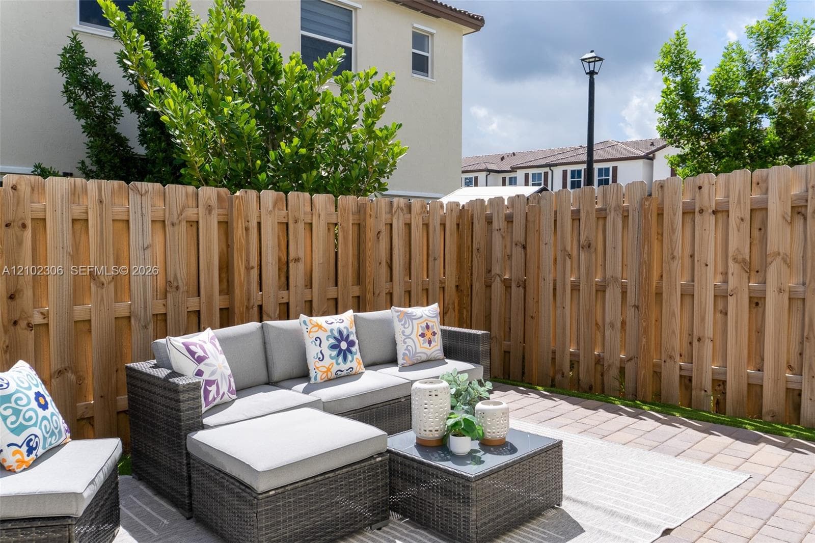 Private outdoor patio featuring light-toned concrete pavers and an enclosed wooden privacy fence