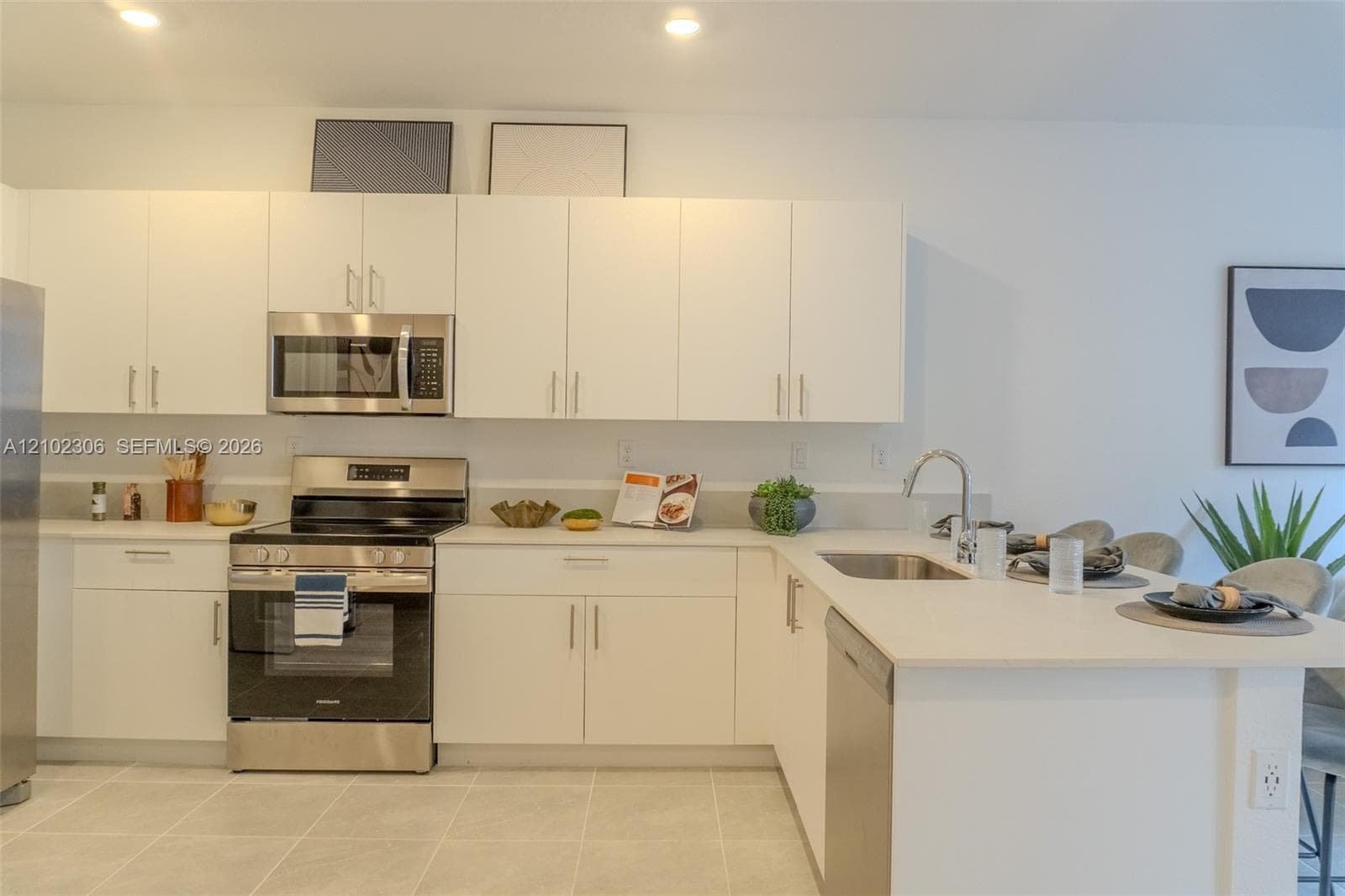 Kitchen featuring white cabinetry, solid-surface countertops, recessed lighting, and stainless steel appliances