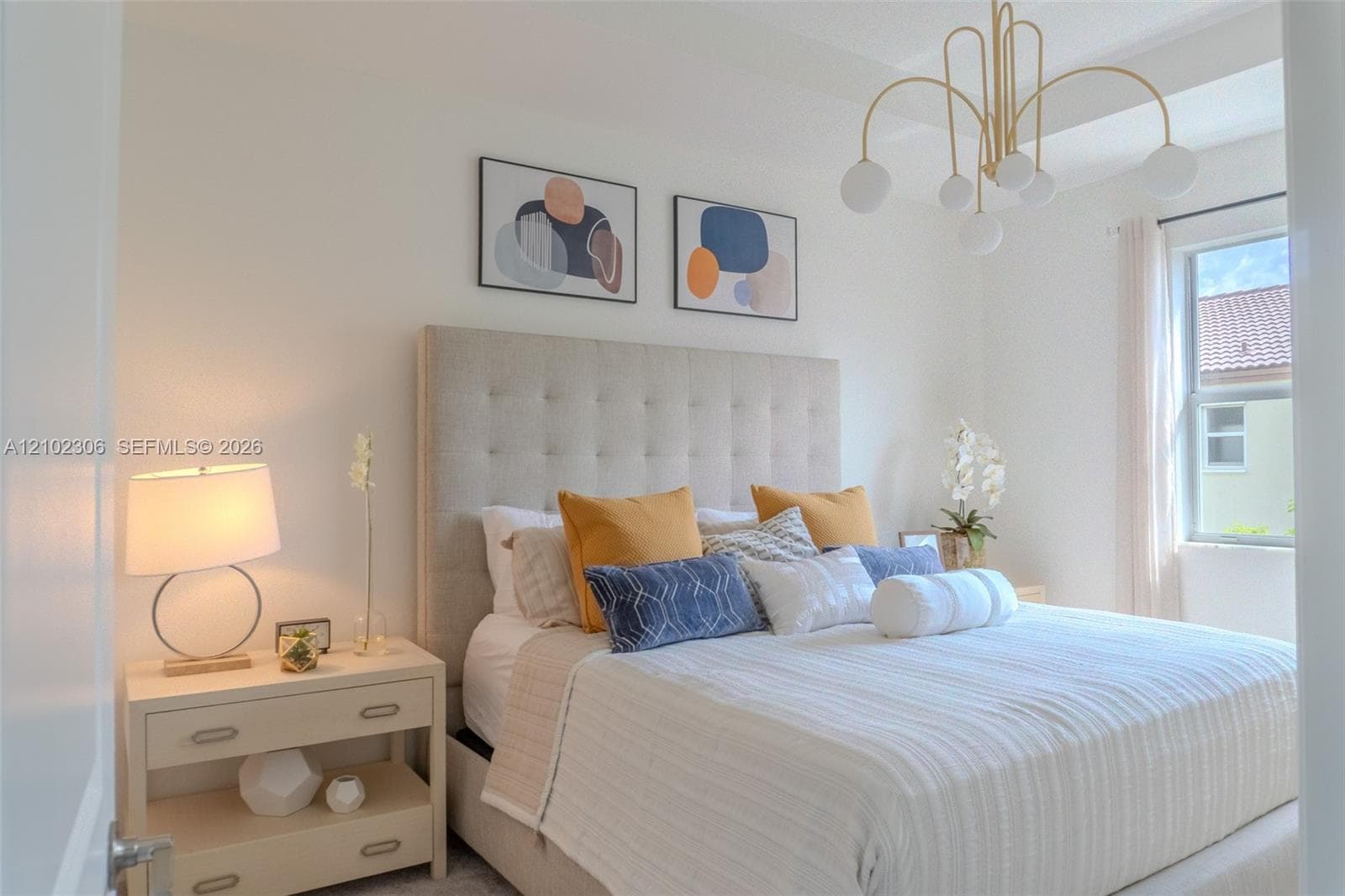 Contemporary multi-arm chandelier with globe-style bulbs, neutral wall palette, and window with casing