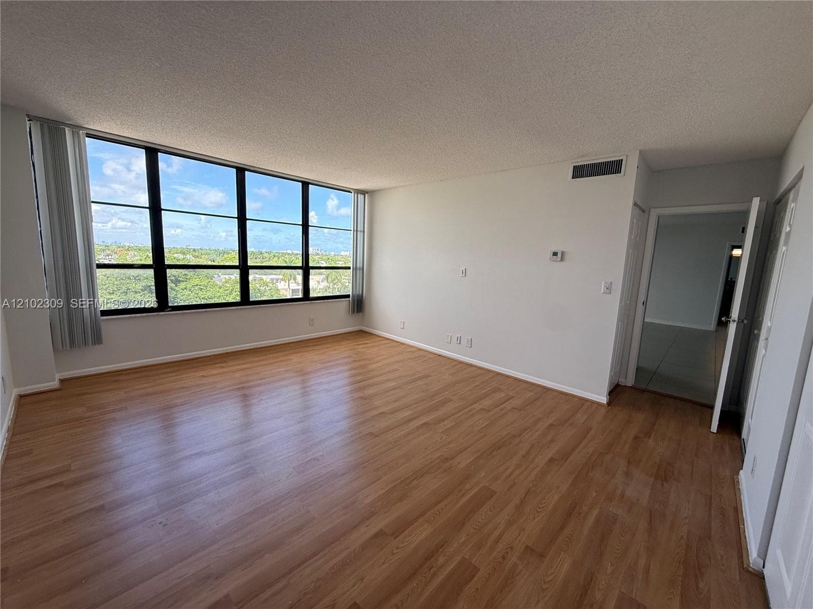 Floor-to-ceiling windows, wood-finish flooring, and natural light exposure