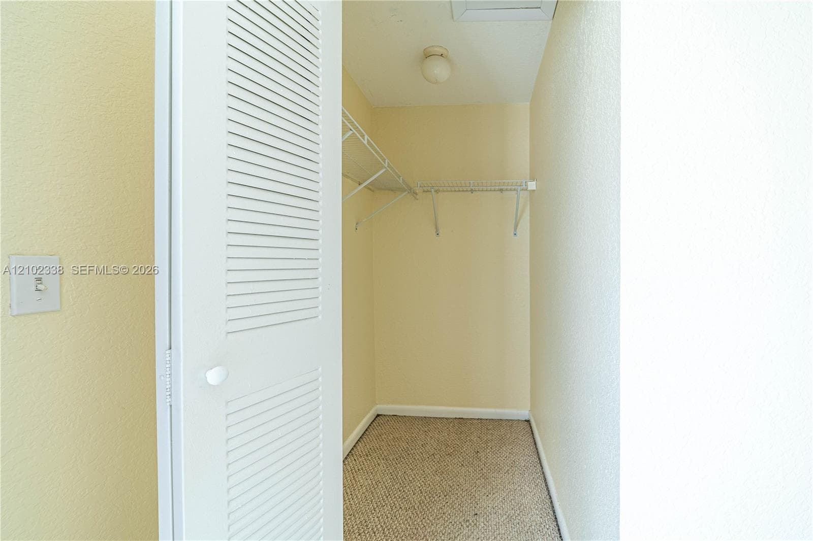 Louvered bifold closet door, interior lighting fixture, and wire shelving system