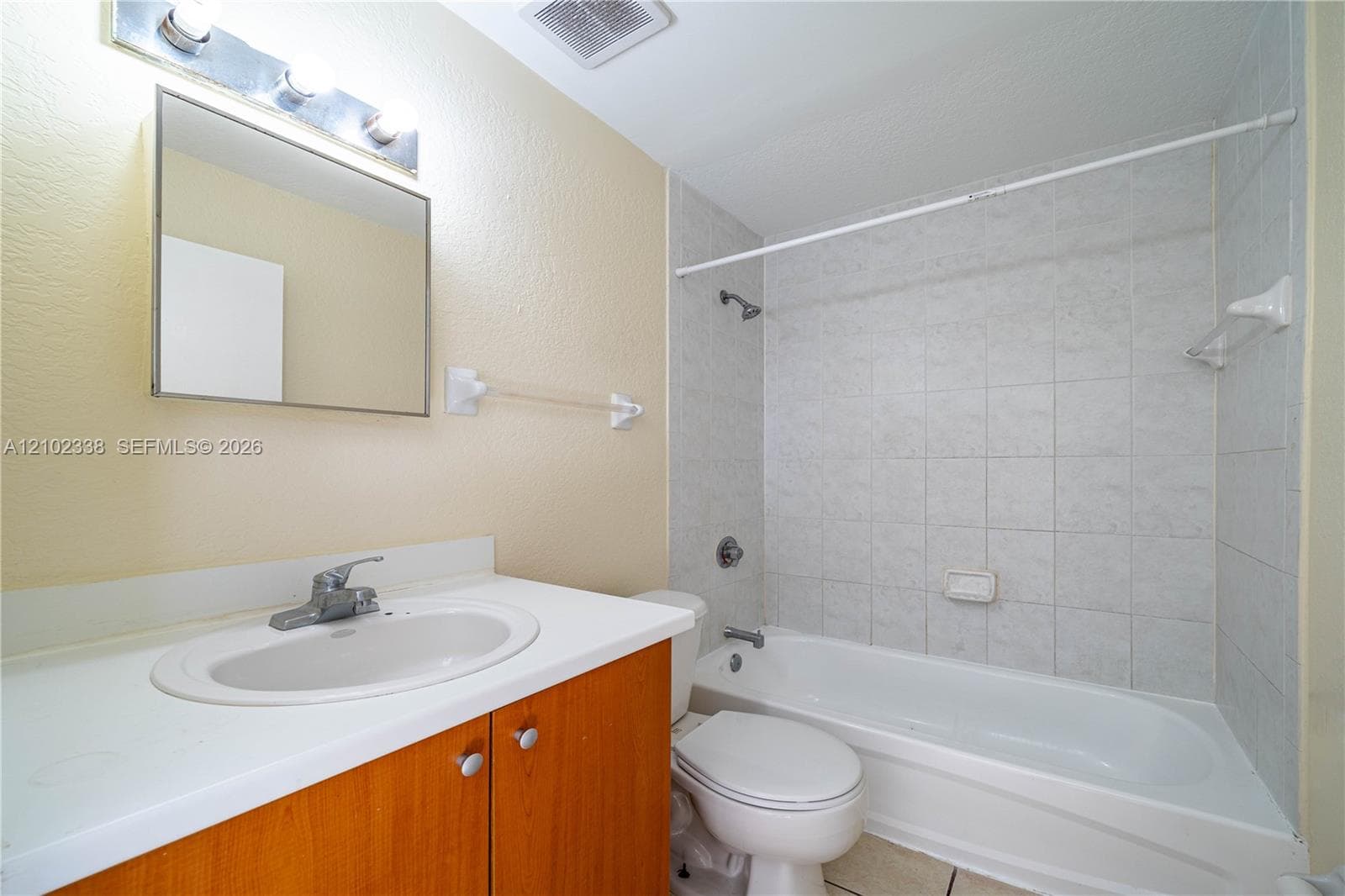 Bathroom featuring a vanity with a white countertop, an integrated sink, and wood-finish cabinetry