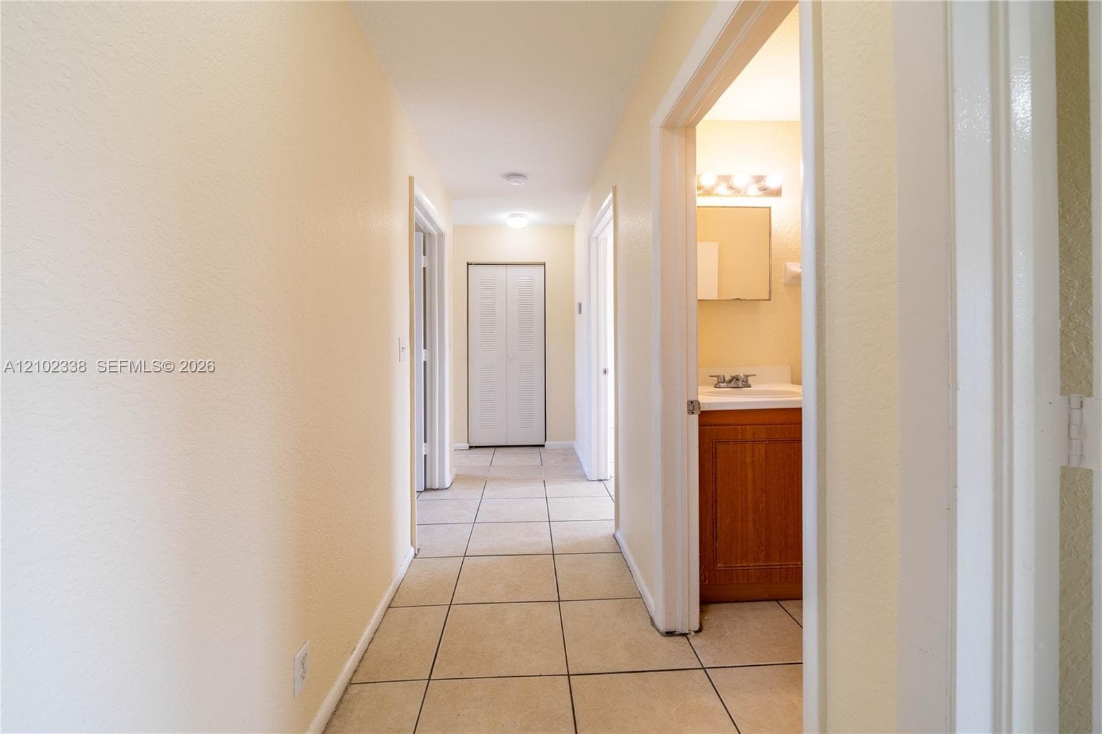 Hallway with tile flooring, light-colored walls, and recessed lighting