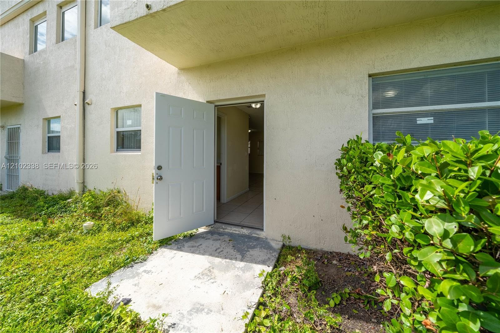 Textured exterior with multiple windows and a solid panel door
