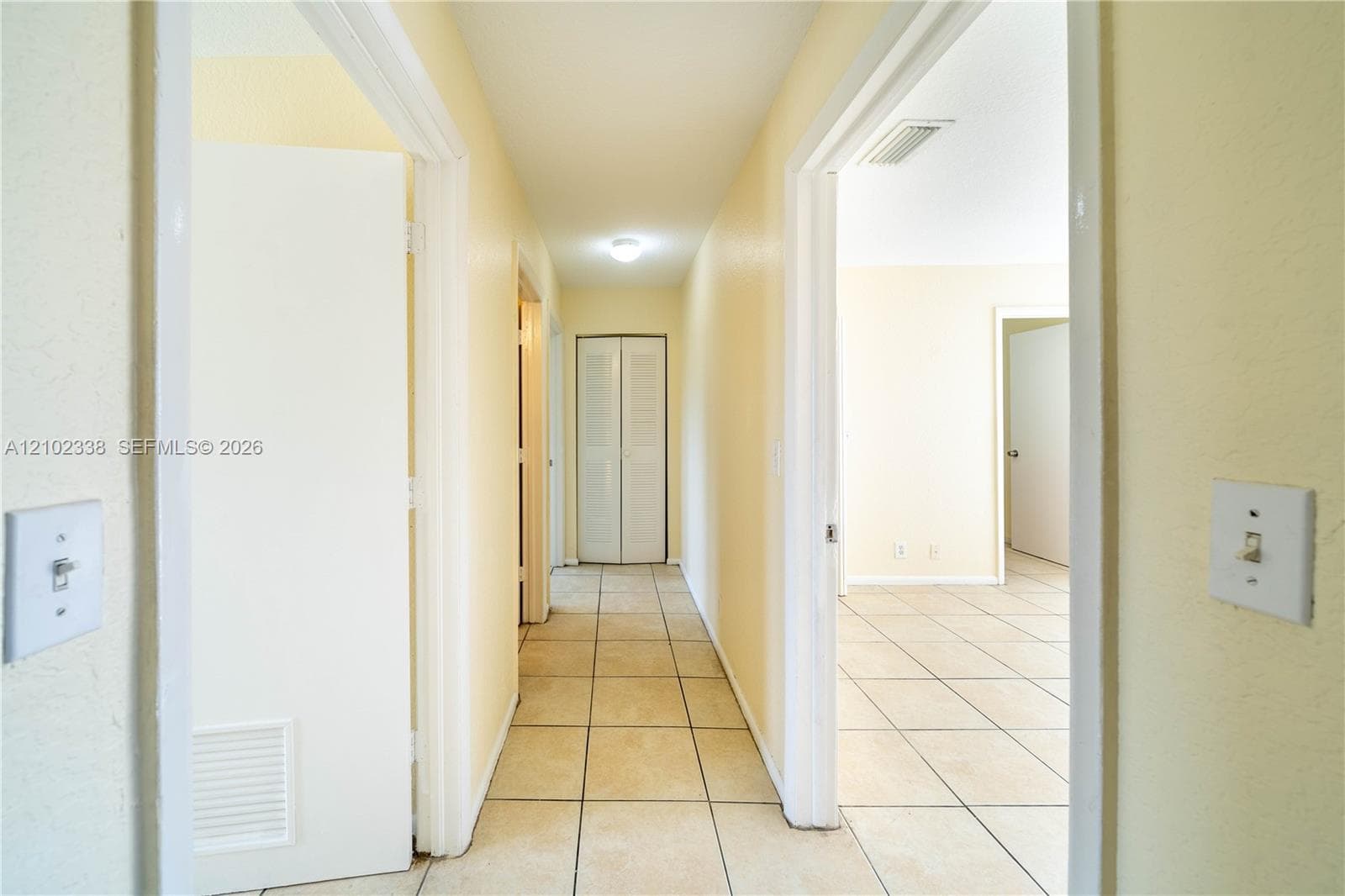 Hallway featuring tile flooring, neutral wall tones, and recessed lighting
