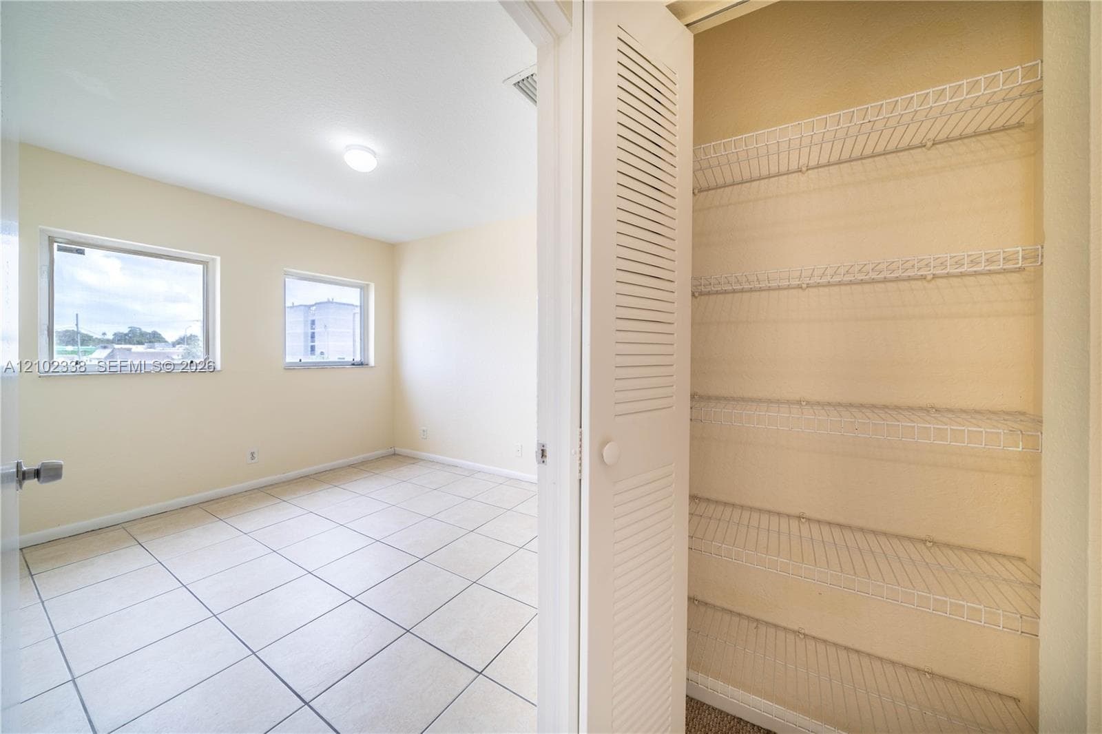 Room featuring two windows, recessed lighting, and tile flooring