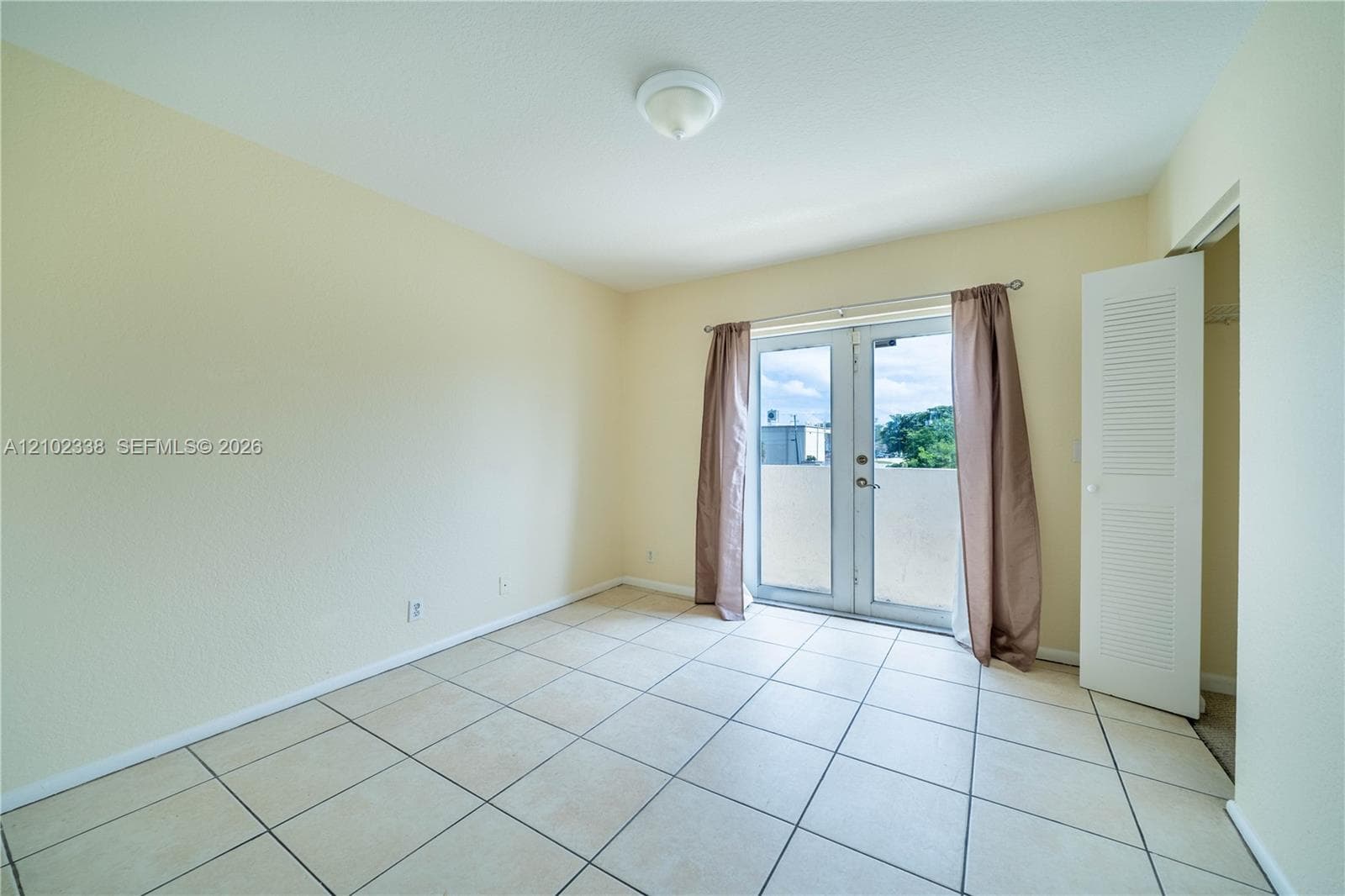 Tiled flooring throughout, light-toned walls, and a ceiling-mounted light fixture