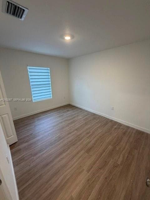 Room featuring wood-finish flooring, neutral walls, recessed ceiling lighting, and a window with horizontal roller shades