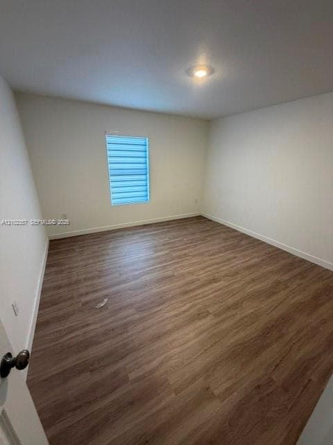 Wood-finish flooring, neutral wall tones, recessed ceiling lighting, and a window featuring adjustable horizontal blinds