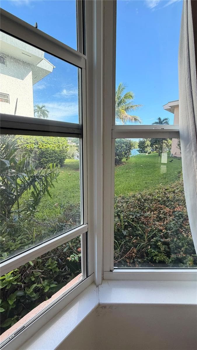 Multi-pane window featuring a wide sill and exposure to exterior landscaping and water frontage