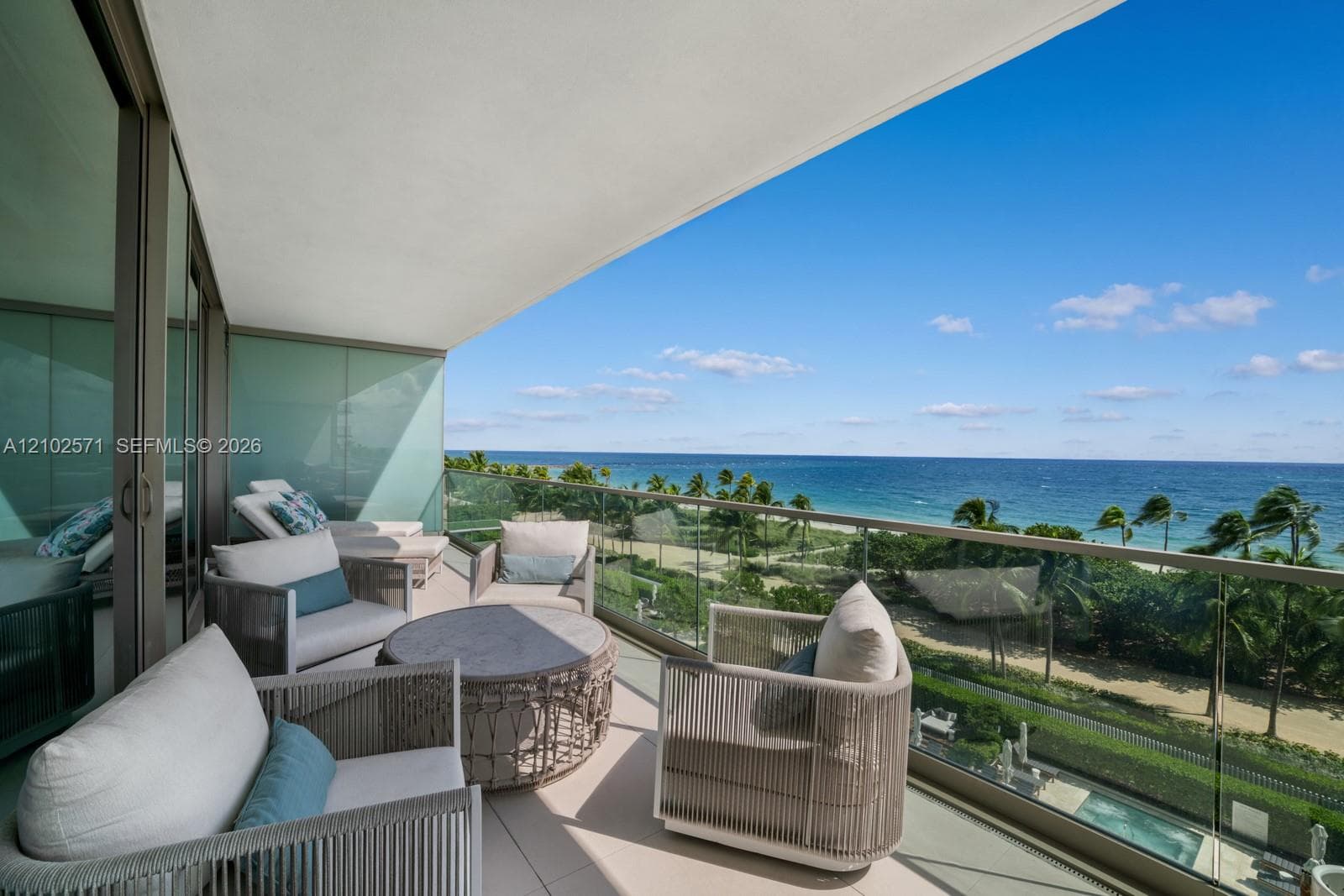 Covered balcony featuring a glass panel railing, tiled flooring, and floor-to-ceiling glass sliding doors