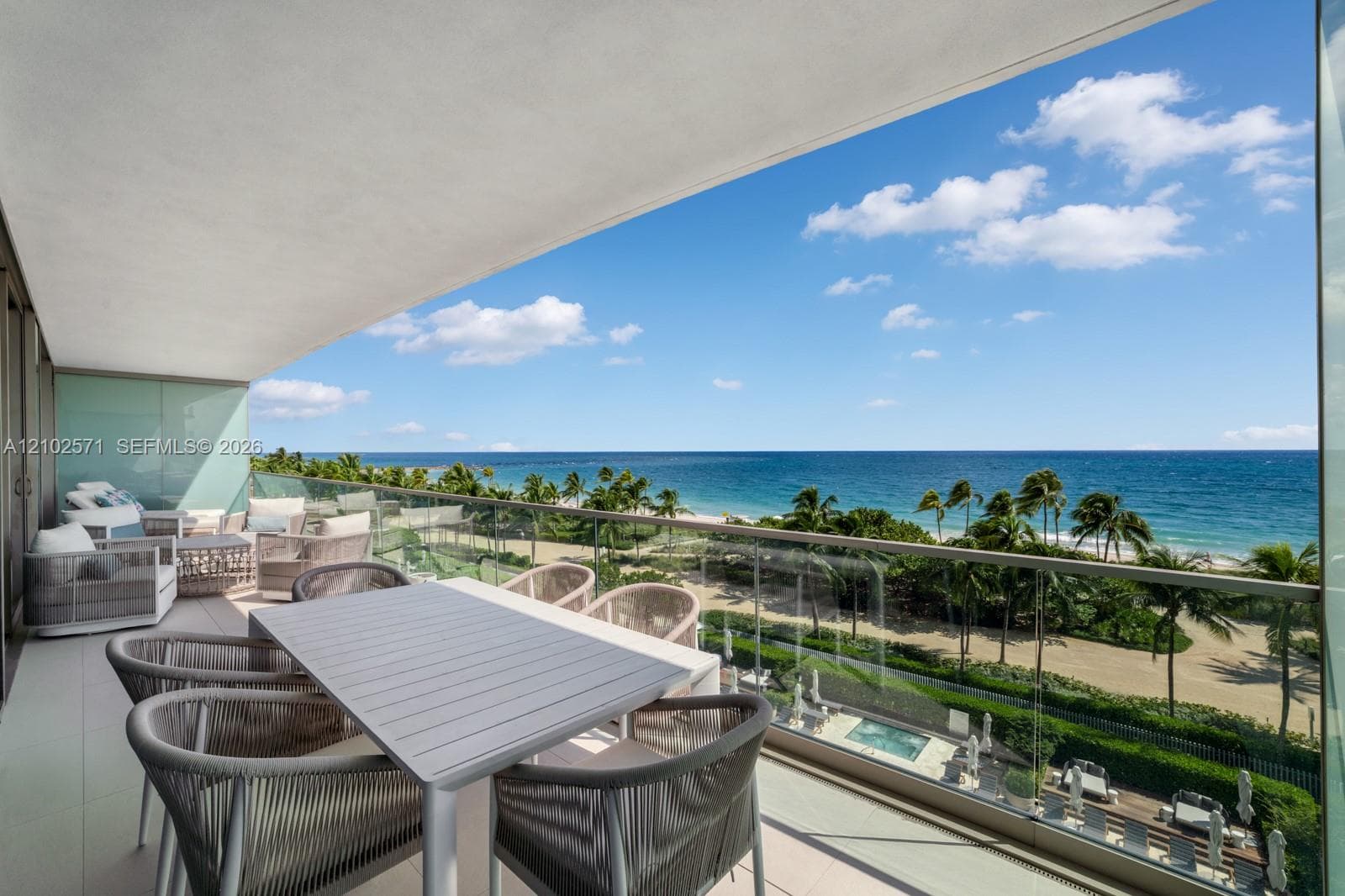 Covered balcony featuring glass railing panels and tile flooring