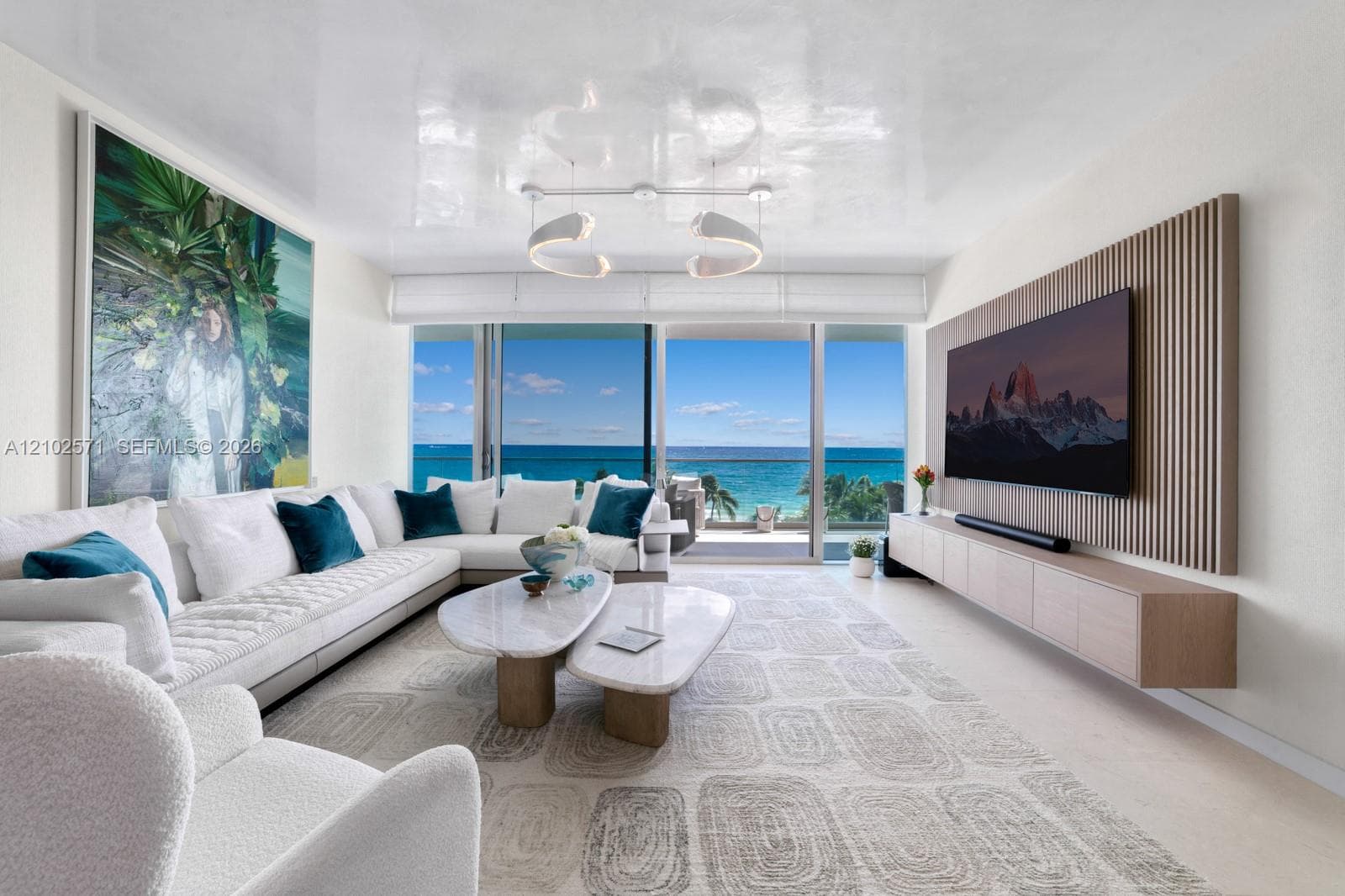 Floor-to-ceiling sliding glass doors, custom wood-slat wall paneling, wall-mounted floating cabinetry, modern curvilinear pendant lighting, and high-gloss ceiling finish