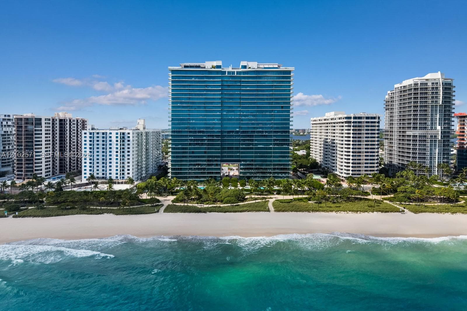 High-rise residential building featuring floor-to-ceiling glass paneling and direct beach access