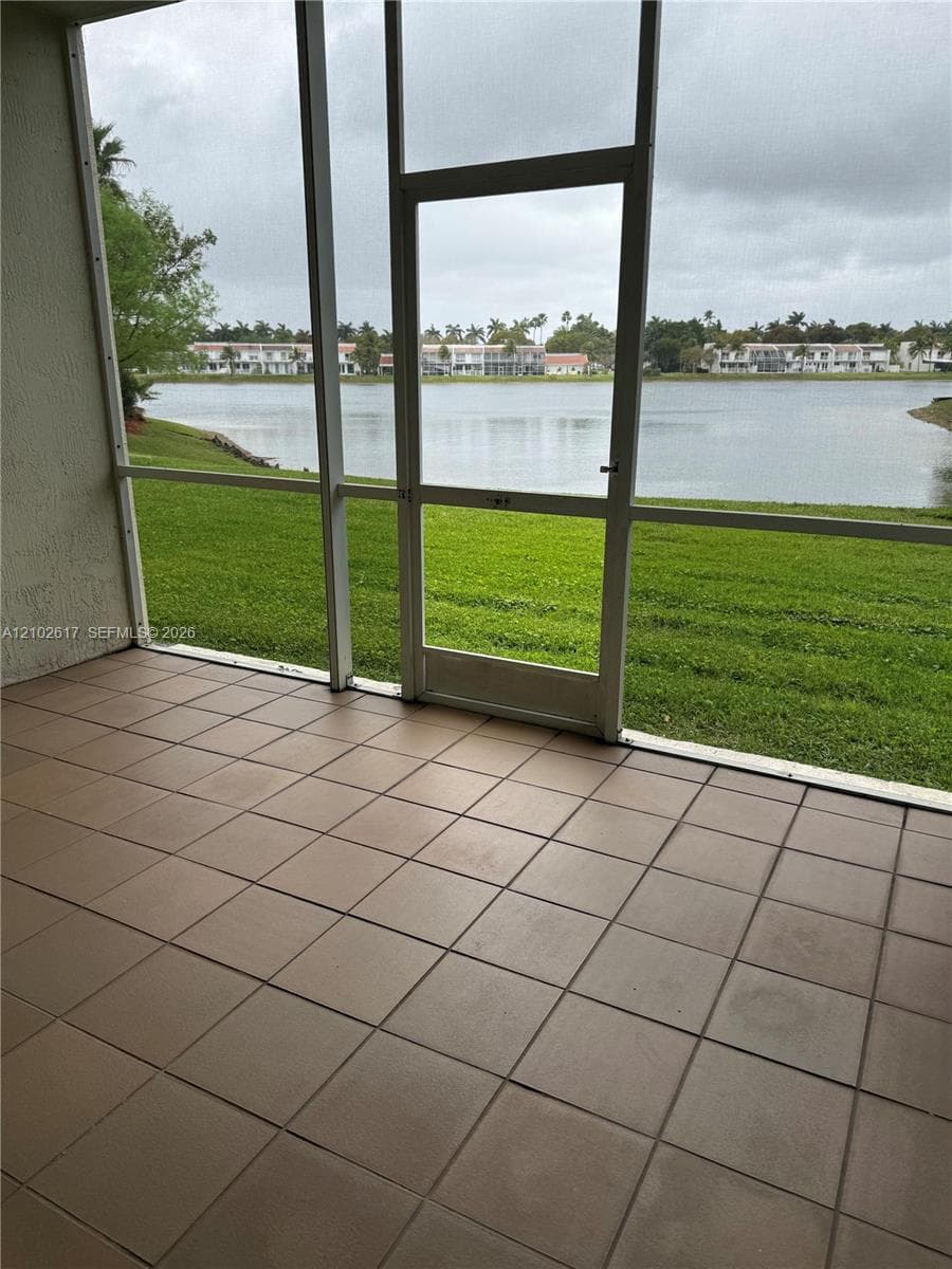 Screened-in lanai featuring square tile flooring and direct water frontage