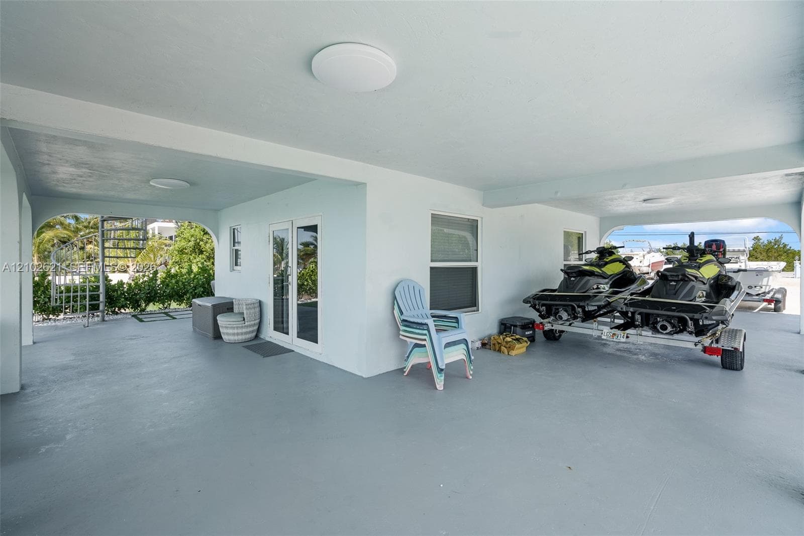 Covered open-air space with concrete flooring, recessed lighting, and white walls