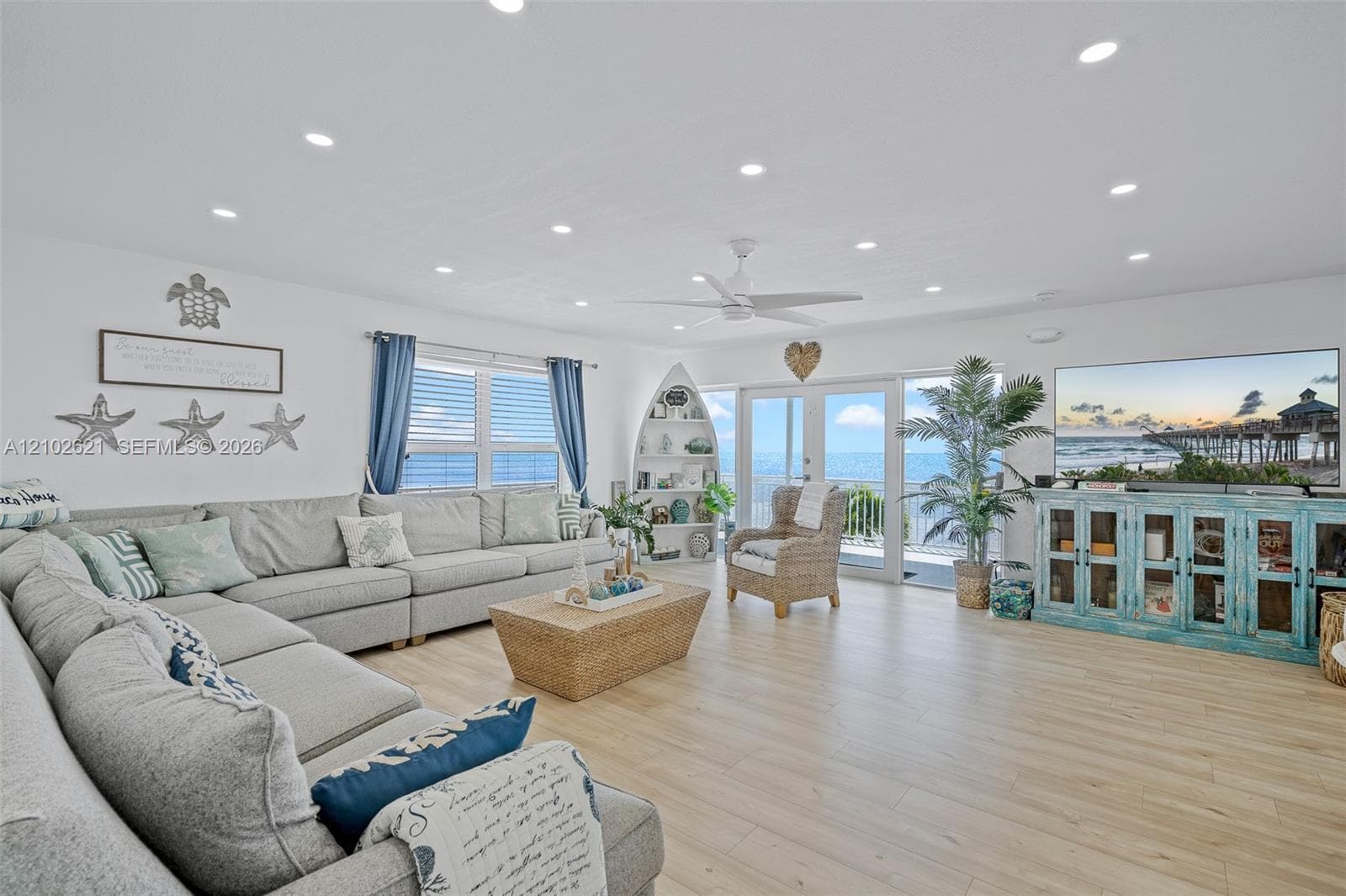 Spacious living area featuring wood-finish flooring, recessed lighting, a ceiling fan, and sliding glass doors opening to the exterior