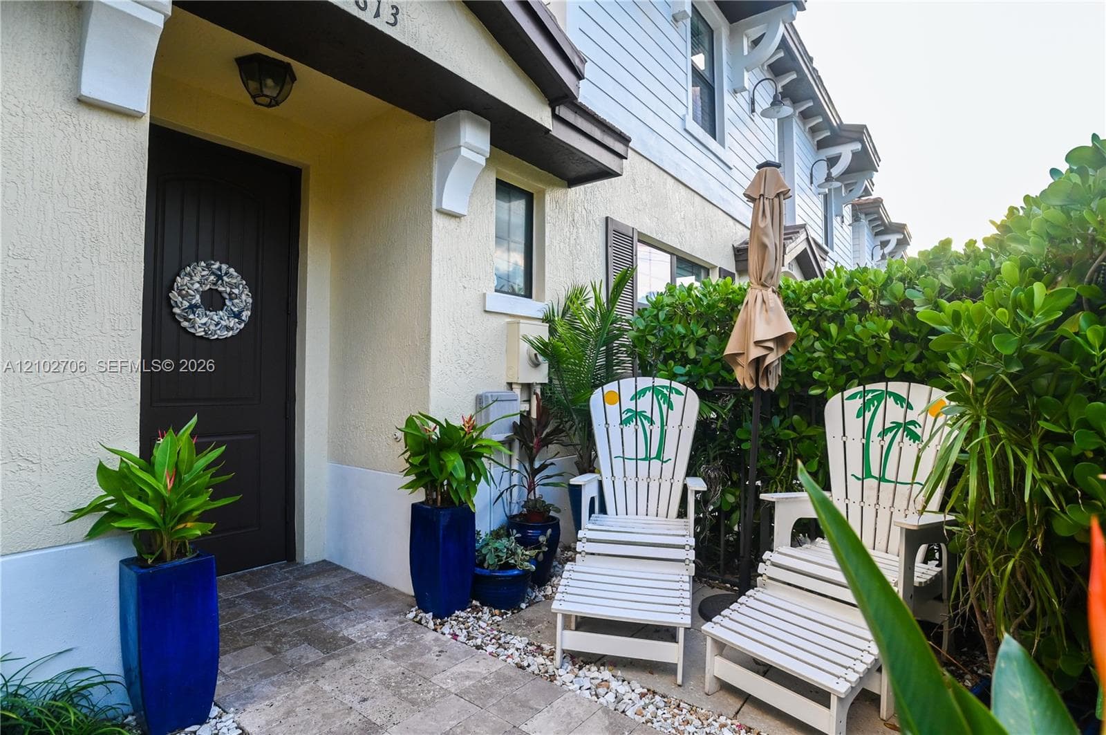 Exterior entryway featuring a solid-panel door, decorative corbel brackets, stone-tile flooring, and low-maintenance siding