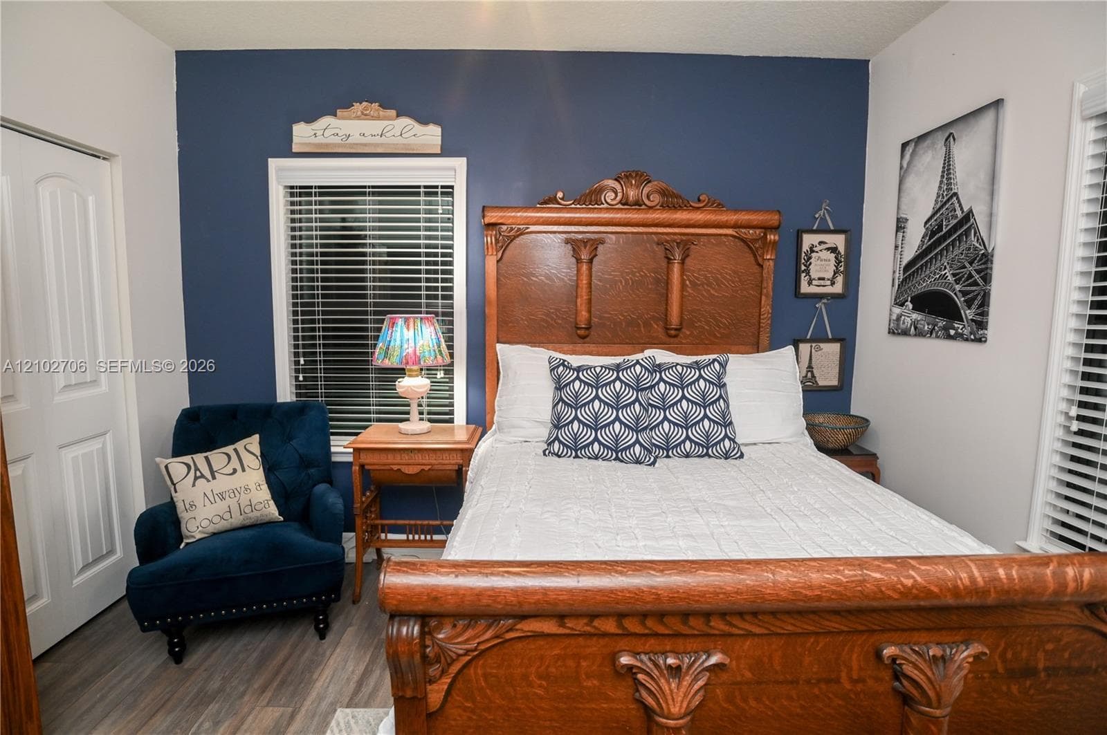 Deep blue accent wall, wood-finish flooring, and white two-panel interior door
