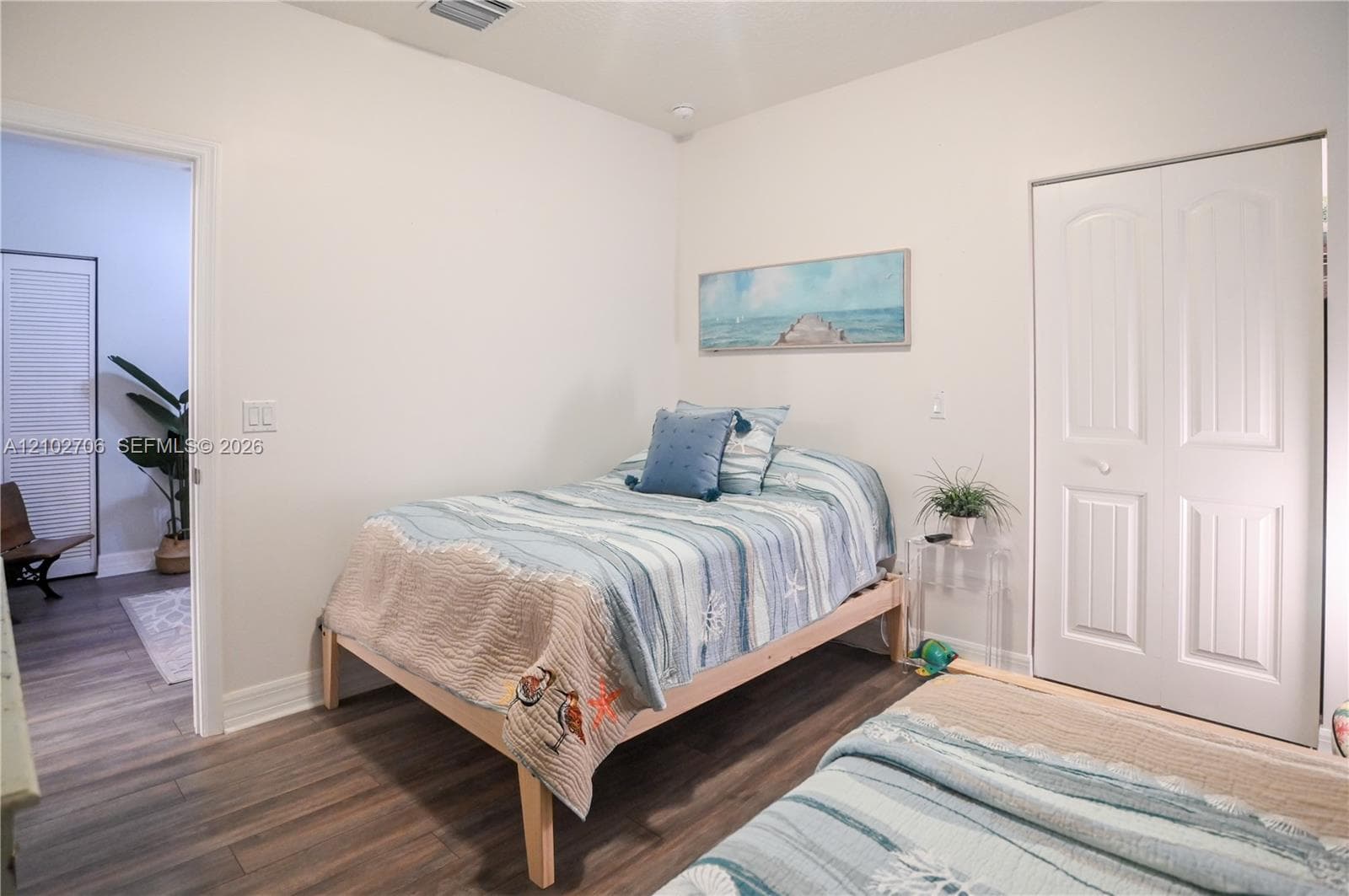 Wood-finish flooring, neutral wall tones, and a double-panel closet door