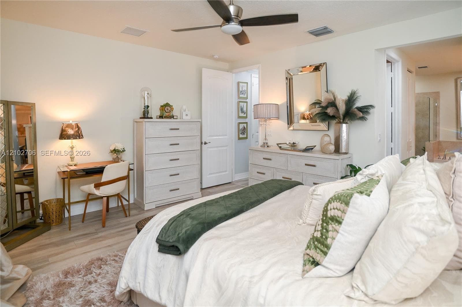 Bedroom featuring wood-finish flooring, a ceiling fan with integrated lighting, and multi-panel interior doors