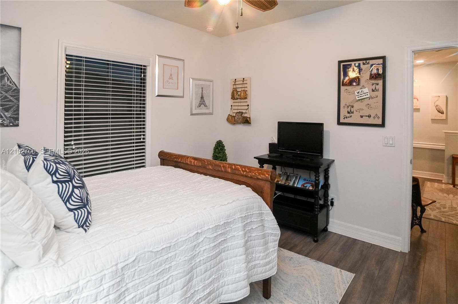 Wood-finish flooring, horizontal window blinds, and a ceiling fan with integrated lighting