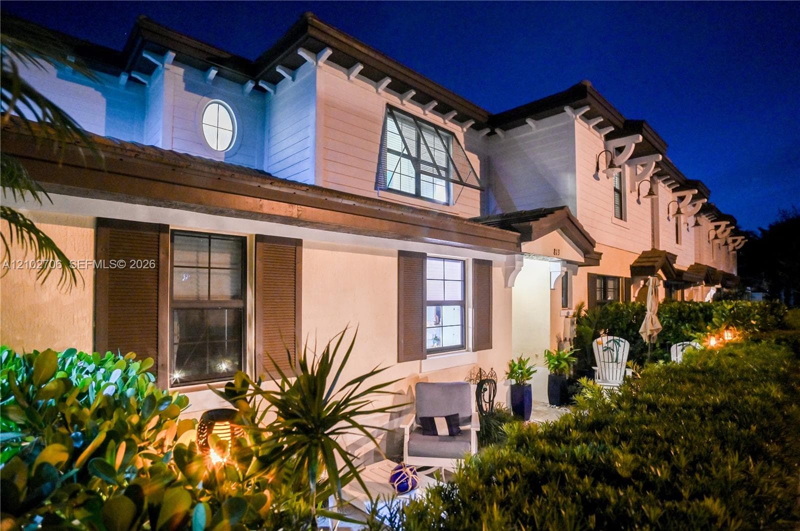Exterior featuring horizontal siding, operable louvered shutters, decorative oval accent windows, and brown roofline trim