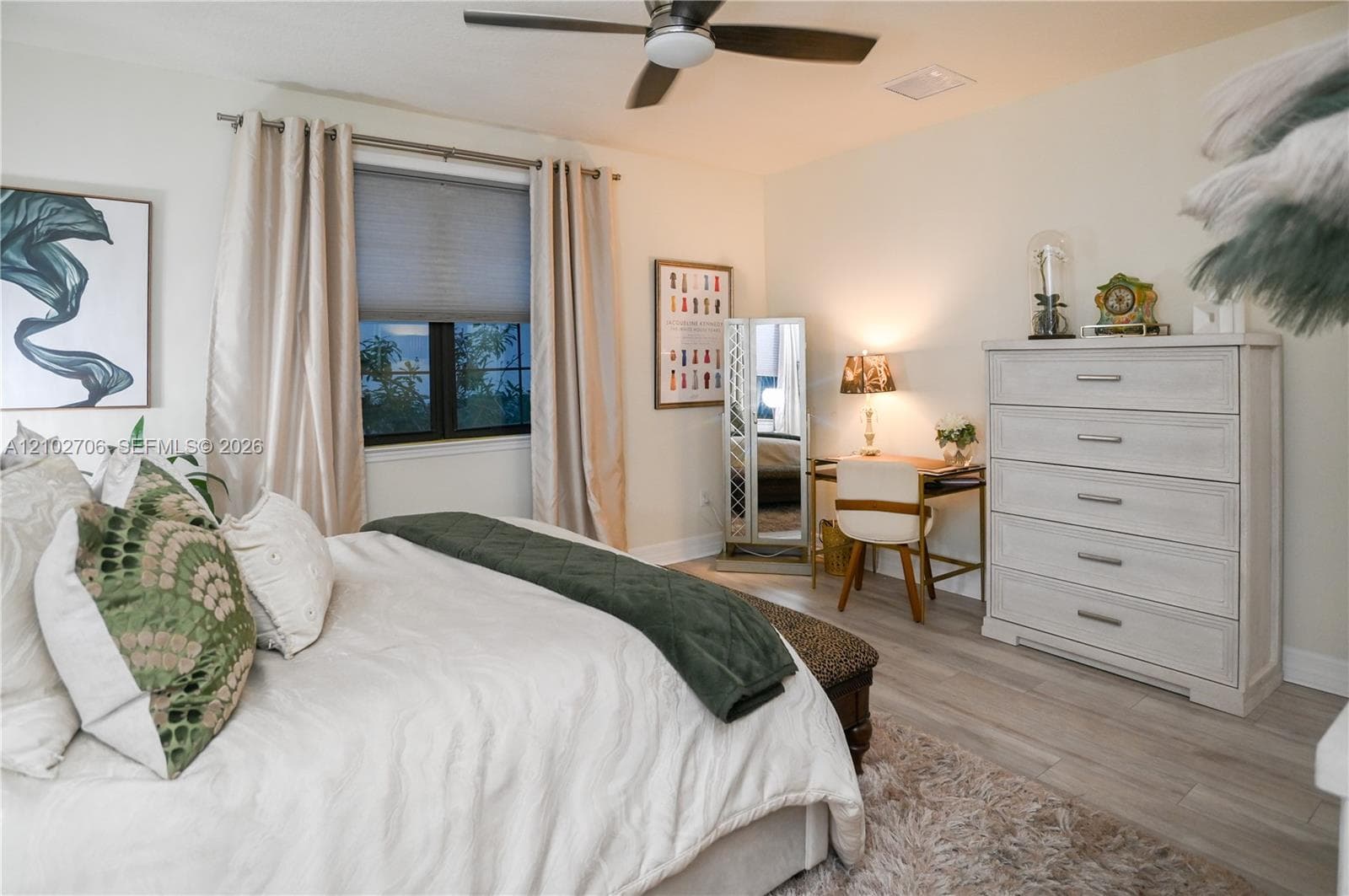 Bedroom featuring wood-finish flooring, a neutral color palette, and a multi-blade ceiling fan with a centered light fixture