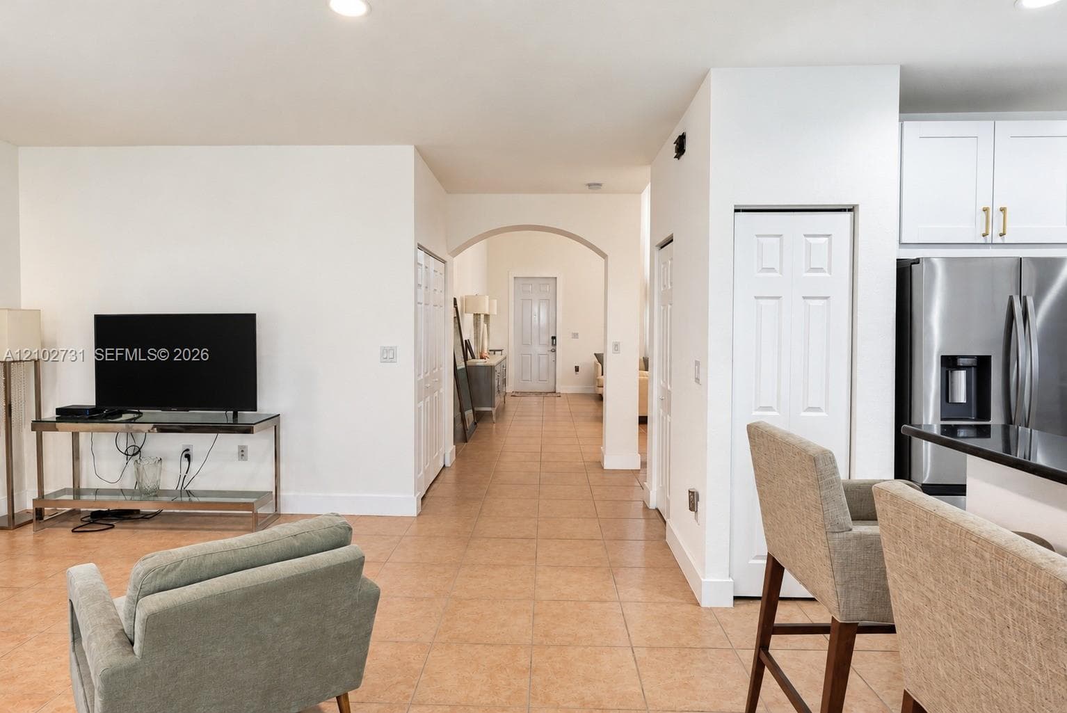 Ceramic tile flooring, arched entryways, recessed ceiling lighting, and stainless steel kitchen appliances