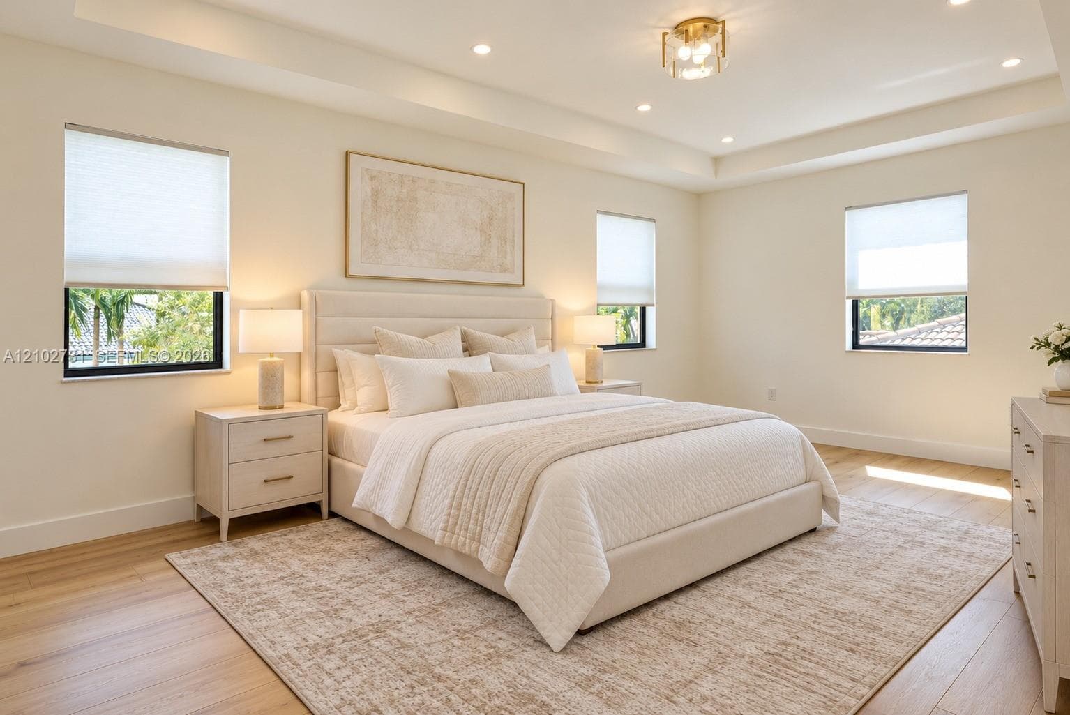 Tray ceiling featuring recessed lighting, light-toned wood-finish flooring, and multiple windows with cellular shades