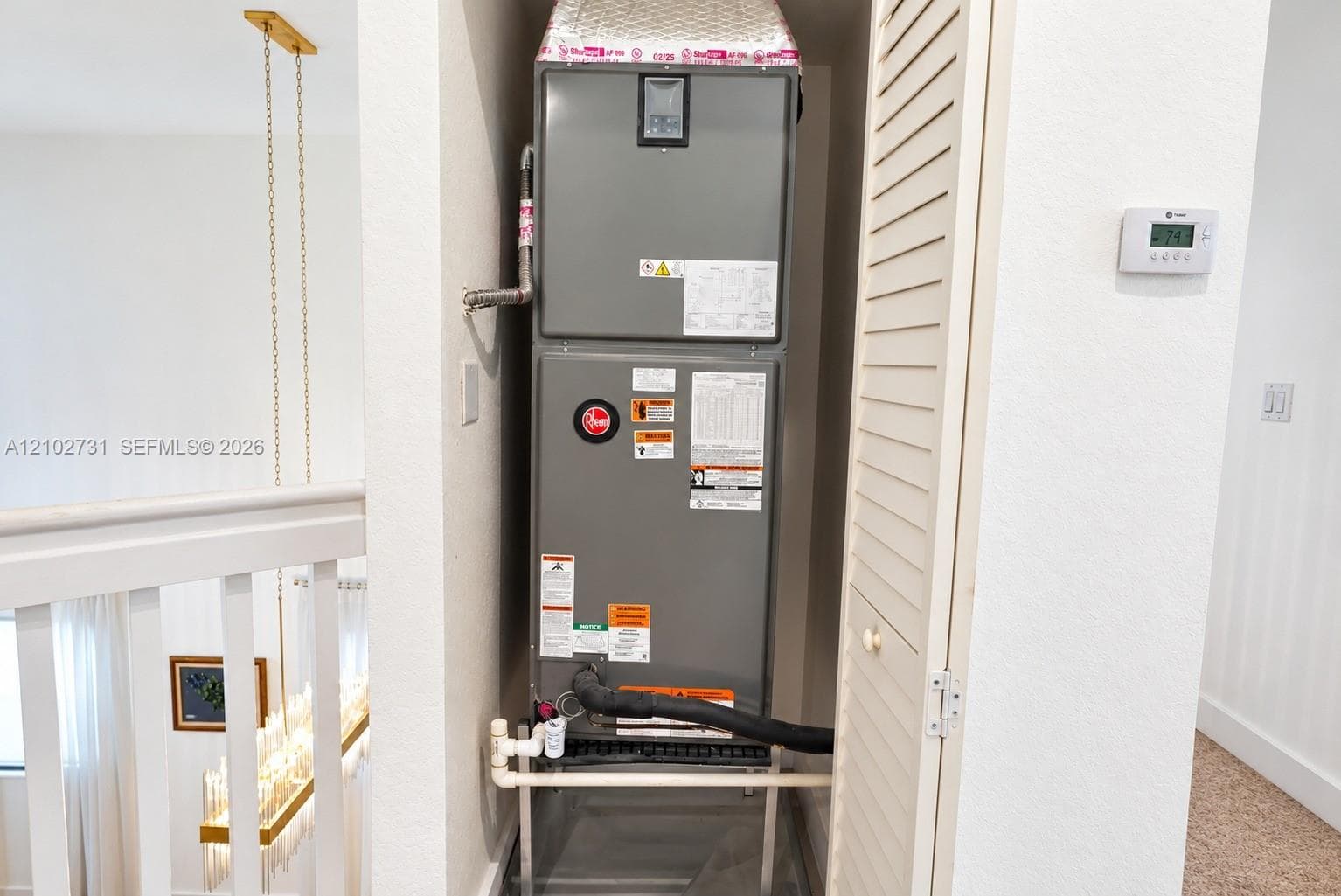 High-efficiency HVAC air handler unit featuring a digital wall-mounted thermostat and louvered closet door enclosure