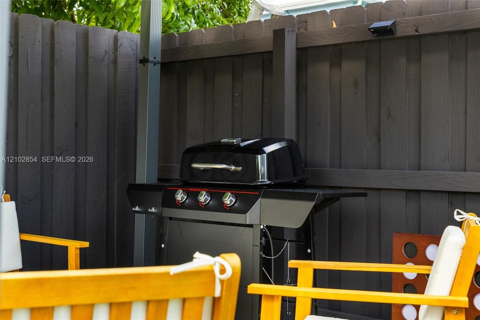 Outdoor space featuring a dark-stained wood privacy fence and integrated solar-powered exterior lighting