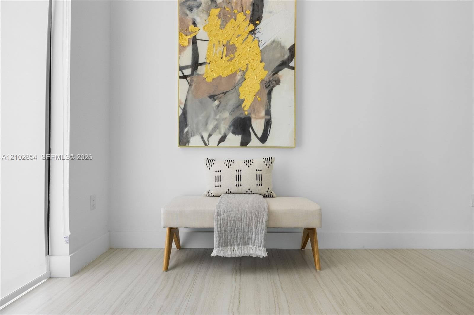 Neutral-toned, wood-finish flooring contrasted with crisp white walls