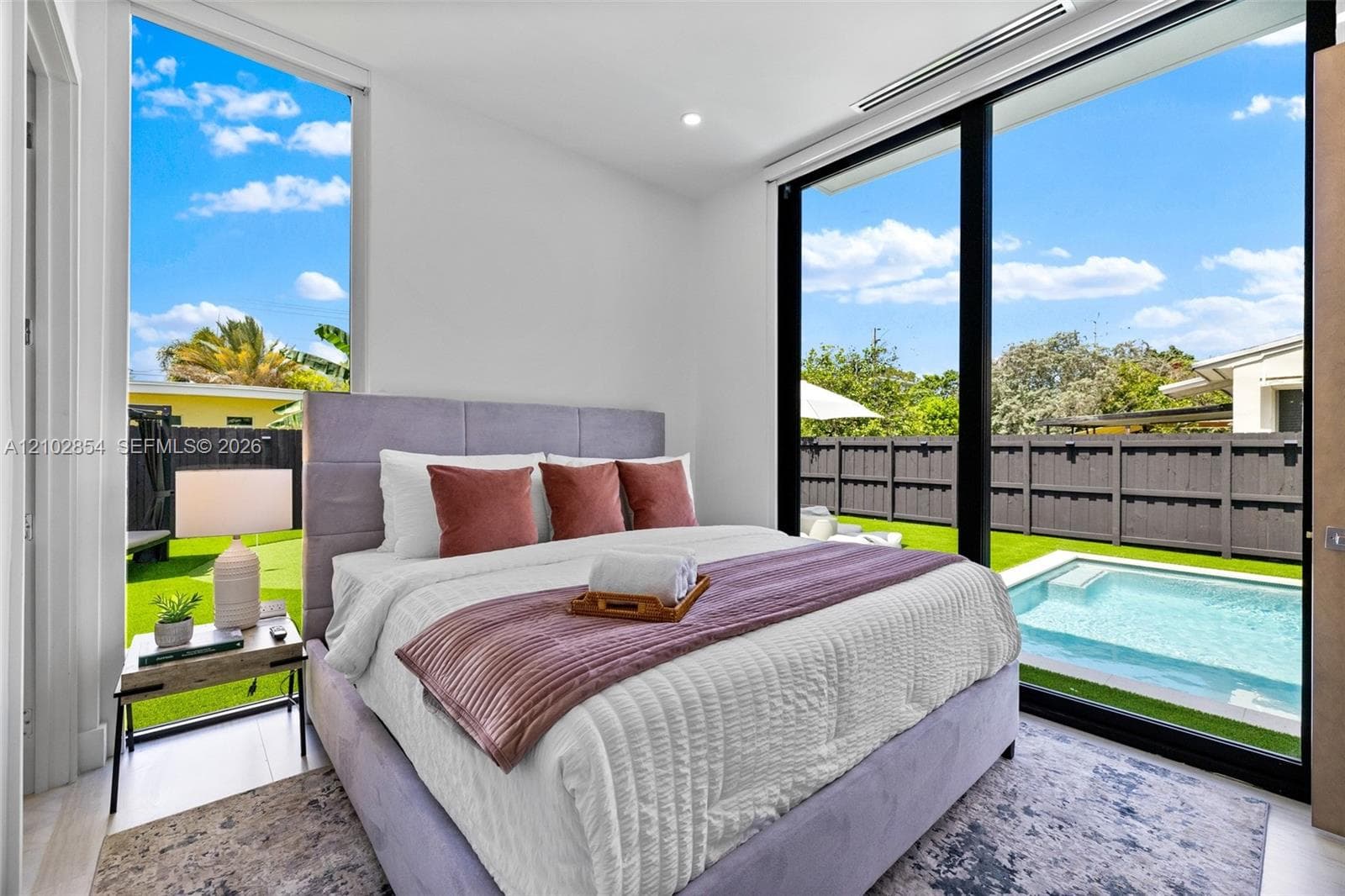 Floor-to-ceiling windows, sliding glass door, recessed ceiling lighting, and exterior access to a private pool and yard