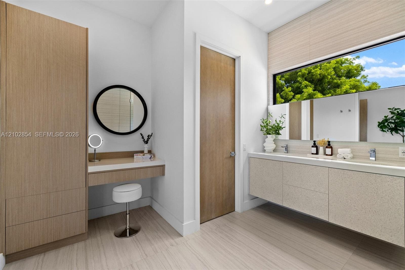 Bathroom featuring a floating double vanity with a stone countertop, integrated cabinetry with a built-in vanity station, recessed lighting, and large horizontal window