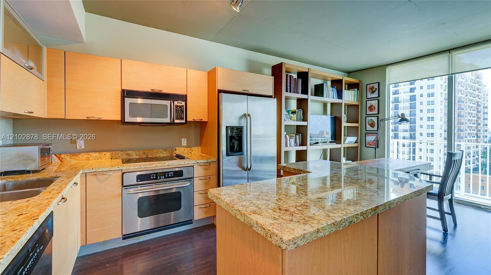 Kitchen featuring natural wood cabinetry, stone countertops, stainless steel appliances, a built-in shelving unit, and wood-finish flooring