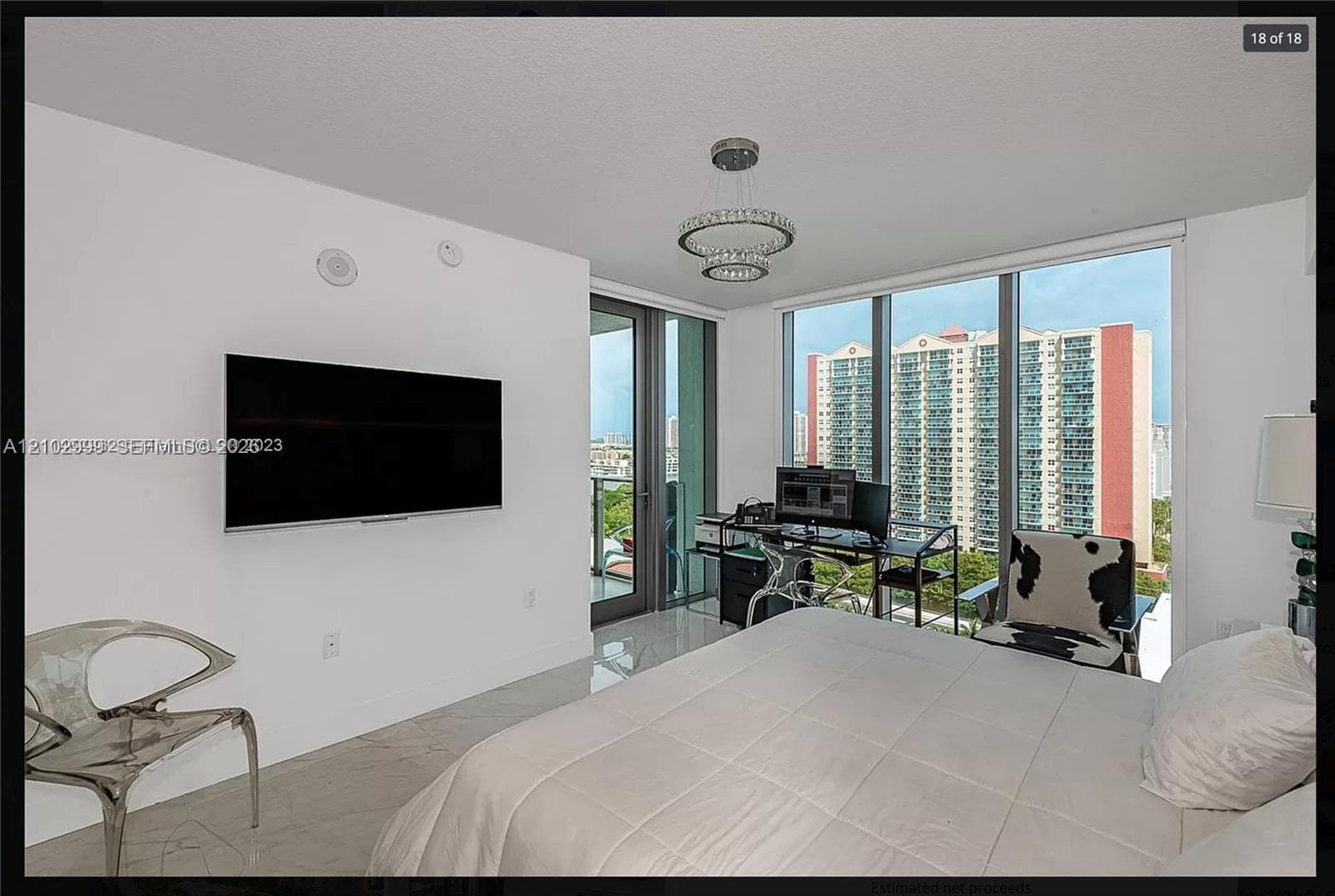 Floor-to-ceiling windows, recessed lighting, and a crystal chandelier